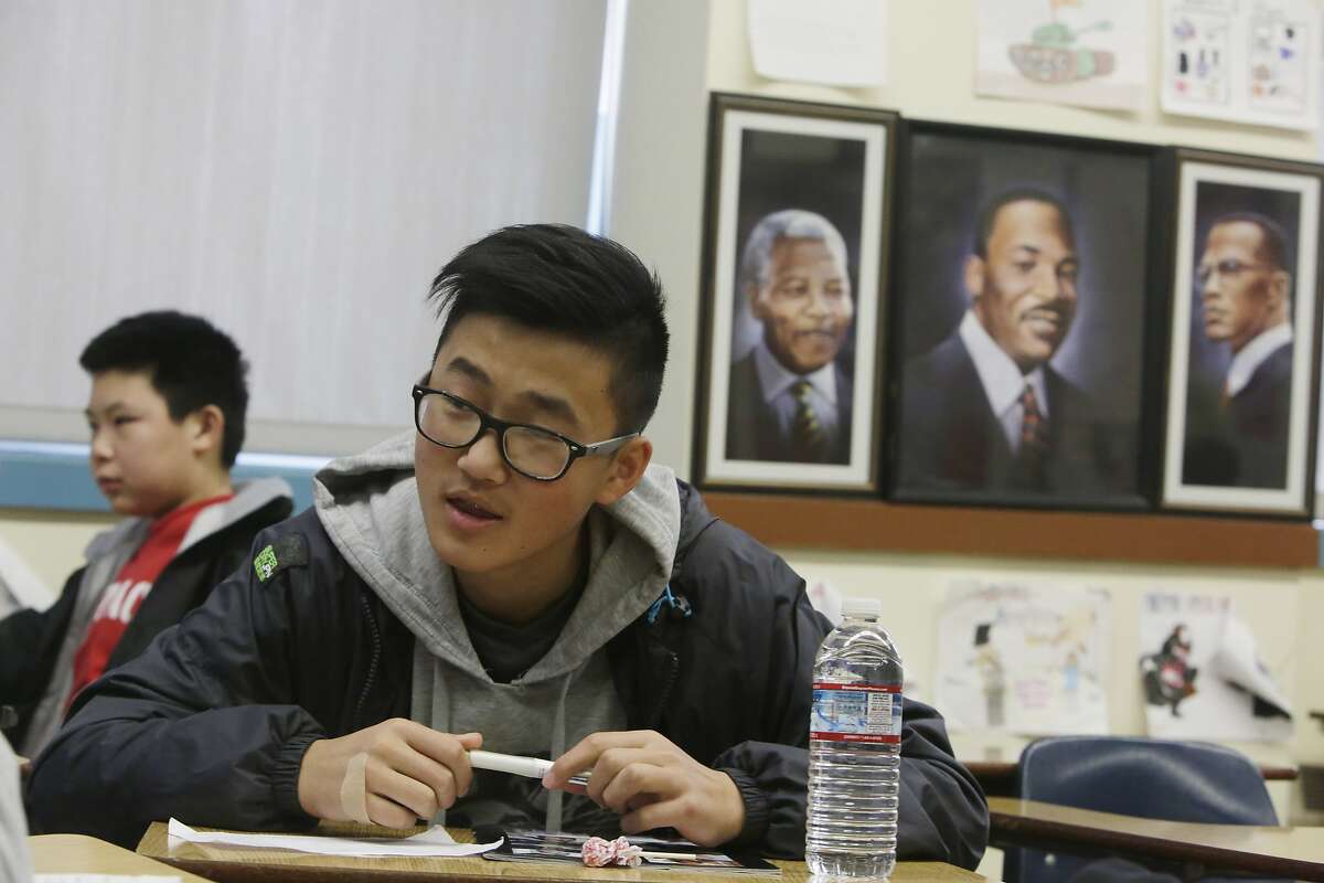 Freshman David Chen (right) sits next to portraits of Nelson Mandela, Martin Luther King, Jr and Malcolm X while working with classmates on a class assignment during ethnic studies class at Washington High School on Wednesday, January 13, 2015 in San Francisco, Calif.
