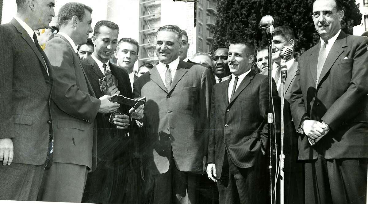 市长乔治·克里斯托弗向奥克兰突袭者队联合队长鲍勃·多尔蒂(左)和汤姆·弗洛雷斯赠送了这座城市的钥匙，以开启突袭者周，突袭者队准备在凯扎尔体育场对阵波士顿爱国者队。照片摄于1960年10月10日