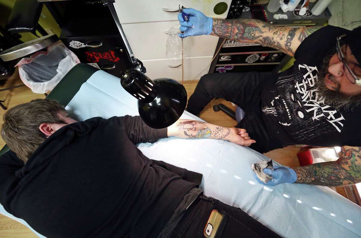 Paramour bar manager Karah Carmack (left) gets a taco tattoo by Carlos Gonzalez Monday Dec. 8, 2015 at Doomsday Tattoo.