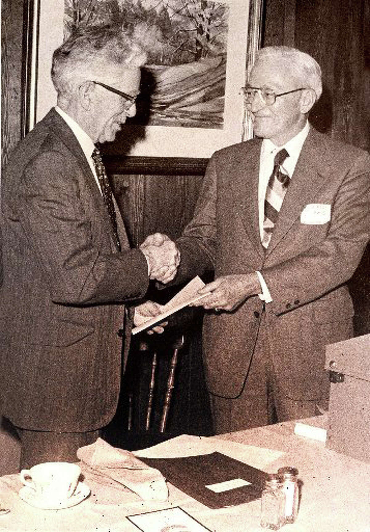 First Selectman John Sullivan receives the deed for open space given to the town by GE, from GE's Robert Lewis. The 1974 acquisition became known as the Cascades at the Lake Mohegan open space.