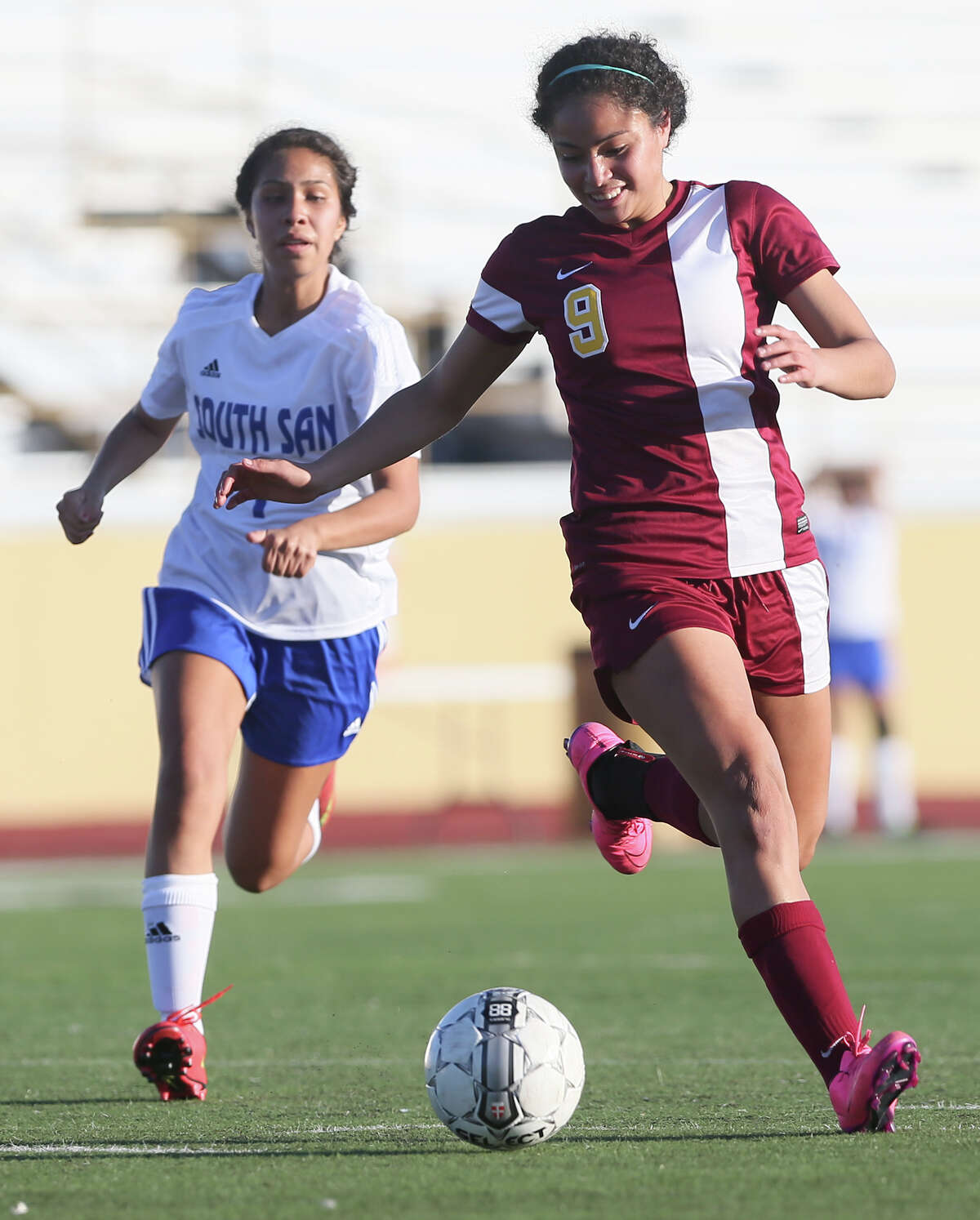 Harlandale's Ingrid Garcia (right) looks to set up a shot as she drives past South San's Selena Sanchez.