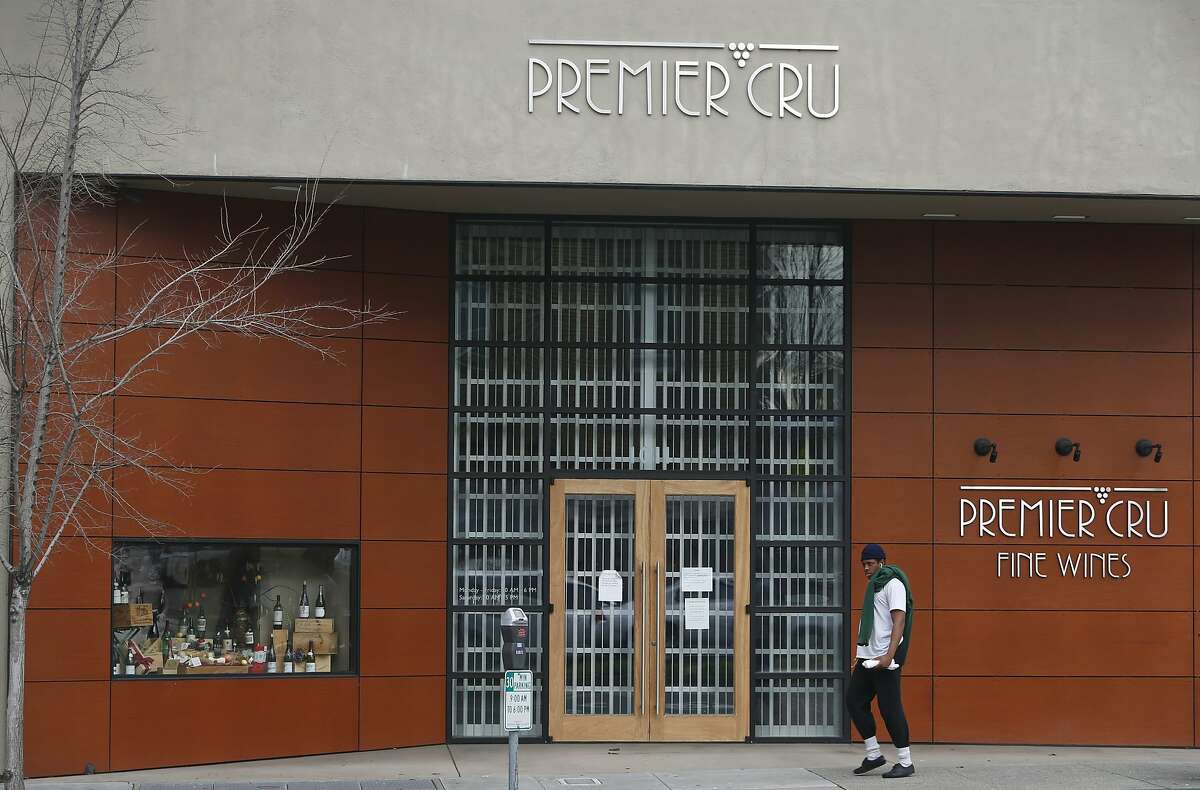 2016年1月14日，星期四，一名男子走过加州伯克利大学大道上关闭的Premier Cru葡萄酒店。葡萄酒期货业务的所有者申请破产，让客户吃了午餐。