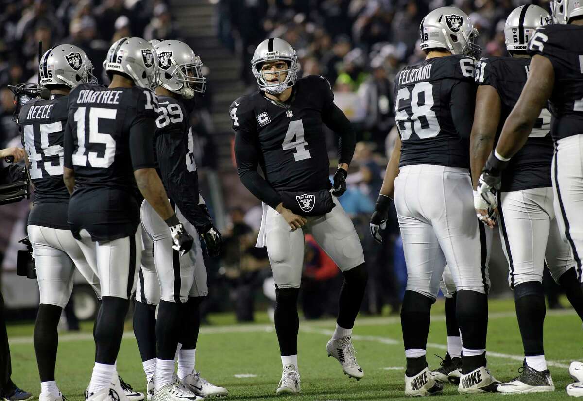 Raiders quarterback Derek Carr (4) huddles against the San Diego Chargers in Oakland, Calif., on Dec. 24, 2015.
