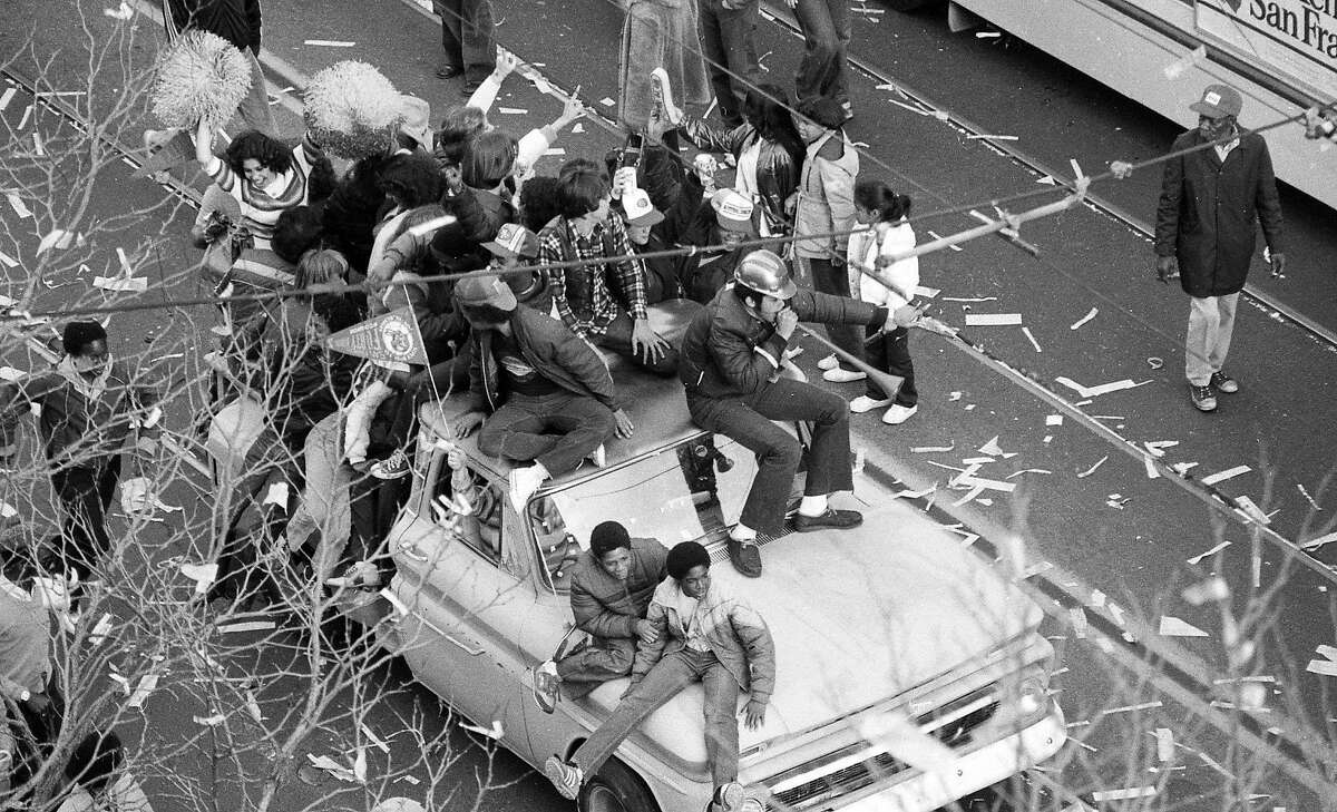 球迷庆祝49人队超级碗十六赢得桩在一辆旧卡车市场街1月25日,1982年。
