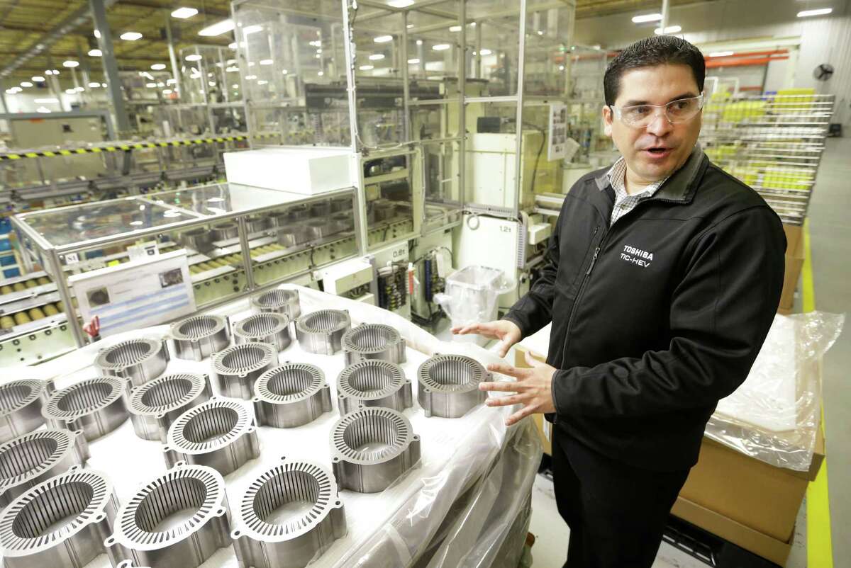 Roberto Heredia, manager at Toshiba's Hybrid Electric Vehicle Motor Plant in northwest Houston, points out generator cores used in hybrid autos. Crews are tweaking the equipment to upgrade it for handling added capacity, Heredia said. ﻿