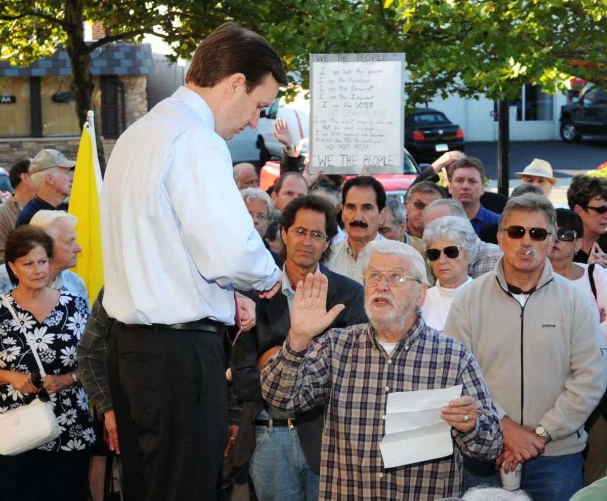 Congressman Chris Murphy, at an outdoor town hall meeting held at the Town Green, in Danbury, CT, on Wednesday, Sept. 2, 2009. Murphy listens to Bob Anger, of Redding, CT, read a statement regarding helathcare reform.