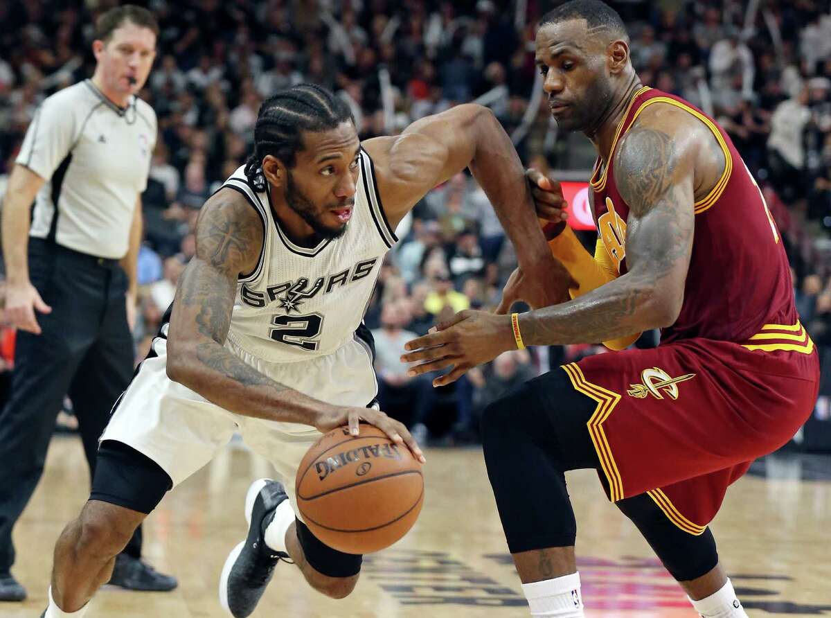 Spurs’ Kawhi Leonard looks for room around Cleveland Cavaliers’ LeBron James during second half action Jan. 14, 2016 at the AT&T Center. The Spurs won 99-95.