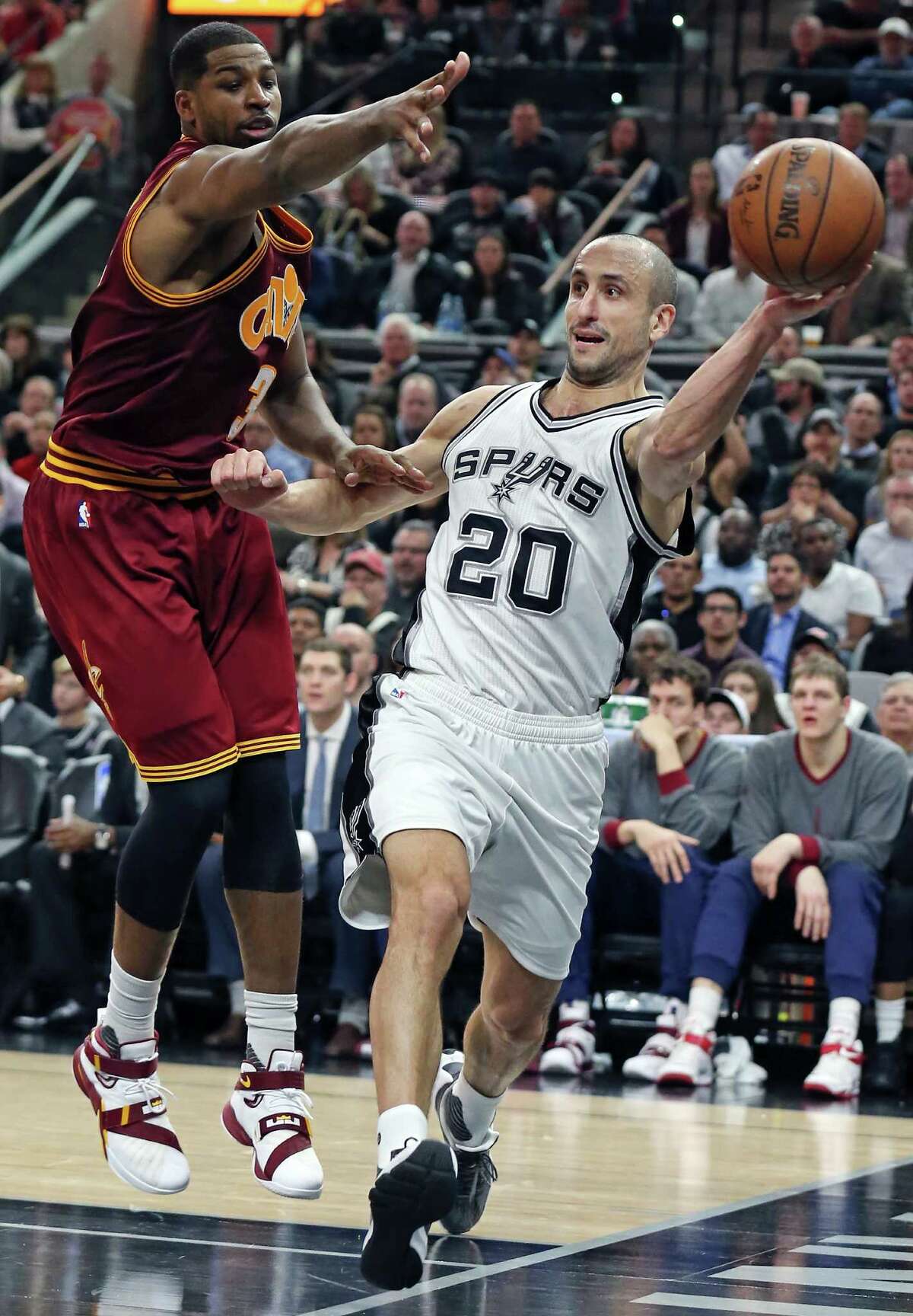 Spurs’ Manu Ginobili pass around Cleveland Cavaliers’ Tristan Thompson during second half action on Jan. 14, 2016 at the AT&T Center. The Spurs won 99-95.