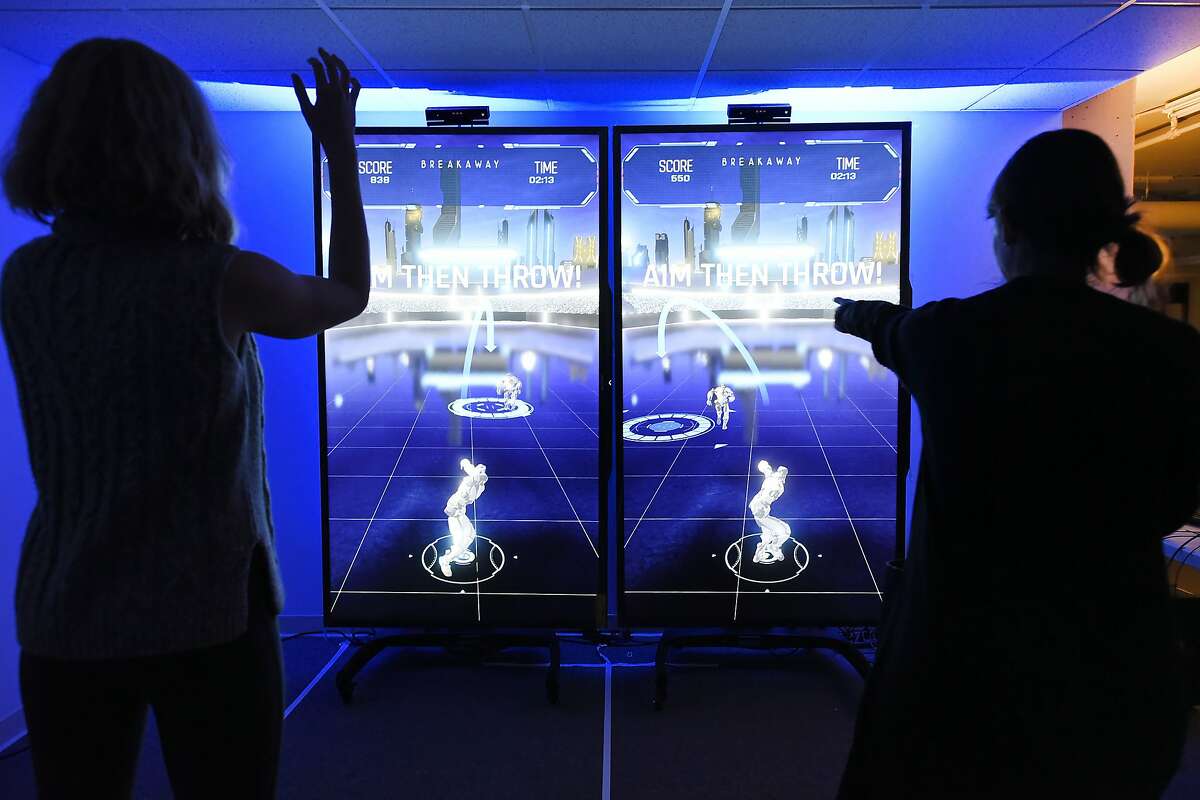 Elaine Cleland, left, and Stephanie Martin of the Super Bowl 50 Host Committee play a motion sensing interactive football game called "Breakaway", at the Britelite Immersive offices in San Francisco, CA on Thursday, January 14, 2016.