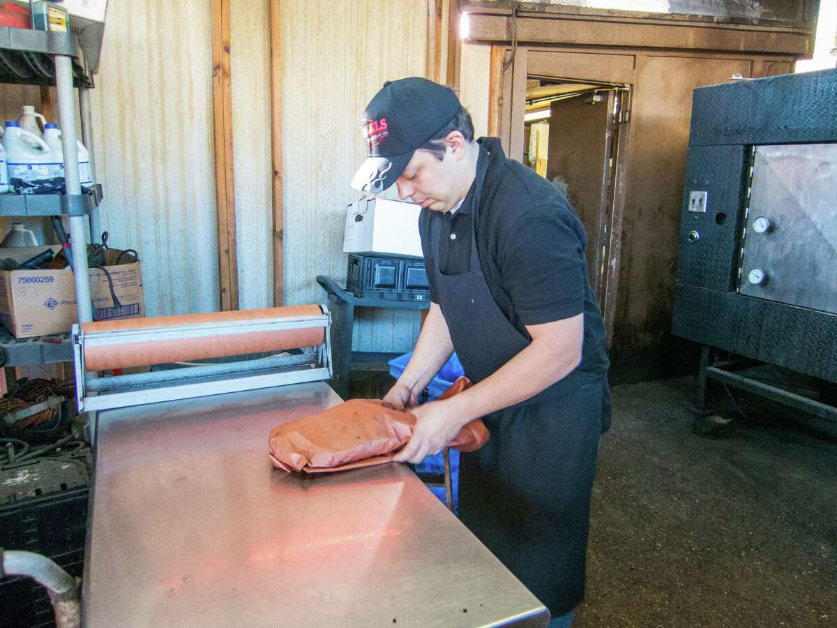 Boris Grekalo of Kazakhstan wrapping briskets at Roegel's Barbecue Co. in Houston.