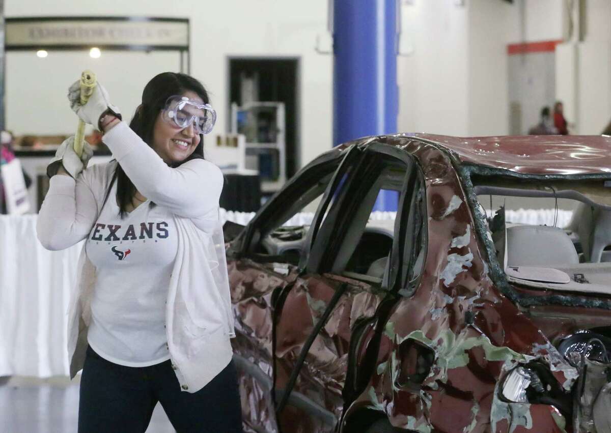 Adilene Flores swings a sledgehammer at a car as part of a Houston Texans promotion at the Bridal Extravaganza Show at the George R. Brown Convention Center Saturday, Jan. 9, 2016, in Houston. ( Jon Shapley / Houston Chronicle )