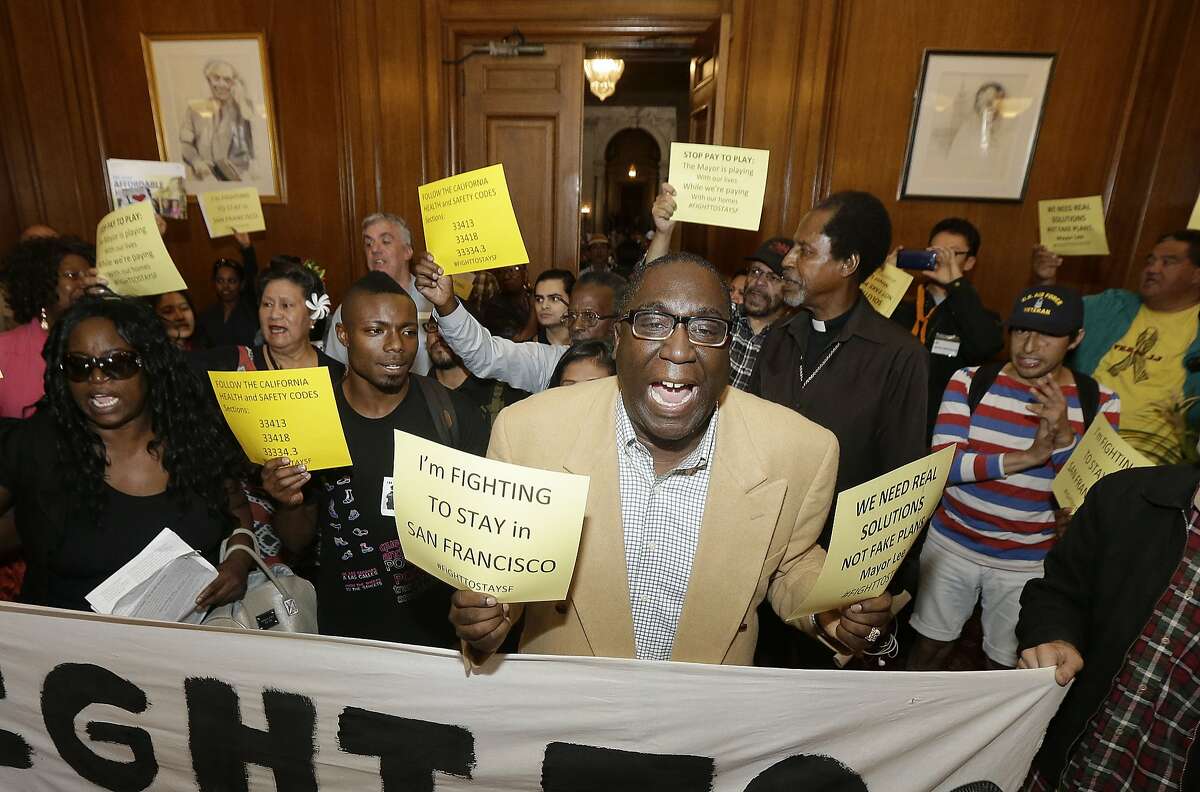 In this Oct. 20, 2015 photo, Pastor Yul Dorn, center, who is facing eviction due to foreclosure, yells as he and others protest evictions in Mayor Ed Lee's office at City Hall in San Francisco. As San Francisco rides a massive building boom, fueled largely by growth in tech-based jobs, many African-Americans worry they will not be able to afford to stay in a neighborhood they've long called home. (AP Photo/Jeff Chiu)
