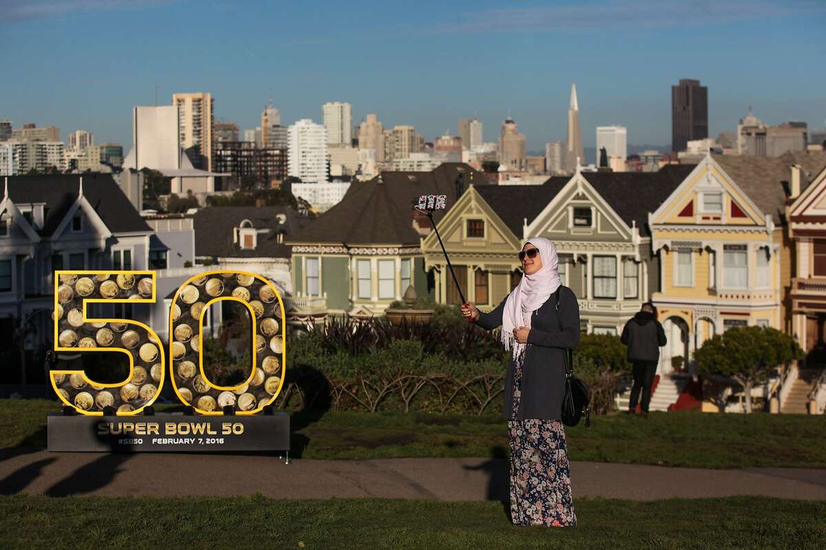 Nihed Kassab, a tourist from Tunisia takes a selfie with a six-foot number "50" sculpture, which was installed as part of the Super Bowl celebration, at Alamo Square Park, in San Francisco, California on Friday, January 15, 2016.