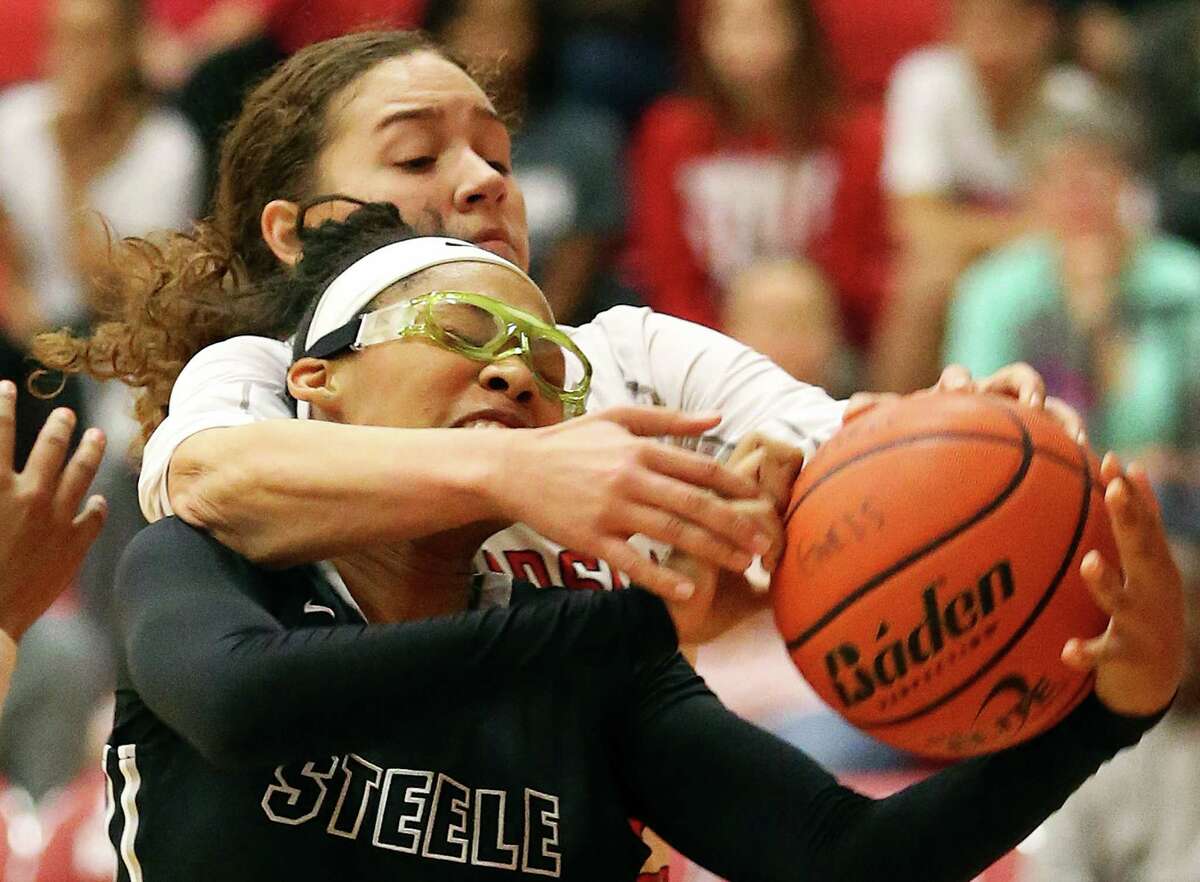 Steele’s Kavin Johnson struggles to control the ball under the hoop with Kyra White of Judson reaching over her back to contest on Jan. 15, 2016.