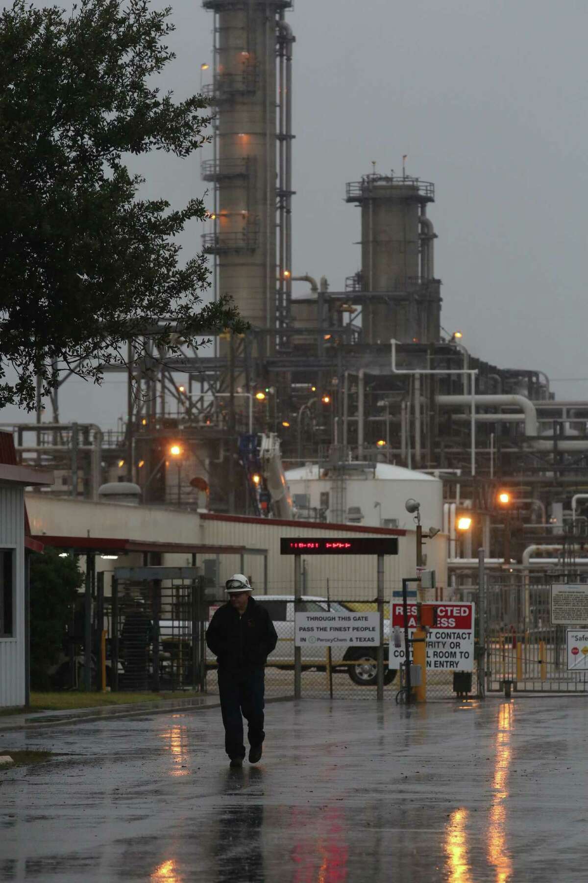 A man walks by the gate of a PeroxyChem plant in the 12000 block of Bay Area Blvd, in the Bayport complex, Saturday Jan. 16, 2016, in Pasadena. One person was killed and three were injured in a chemical explosion or leak, according to authorities.