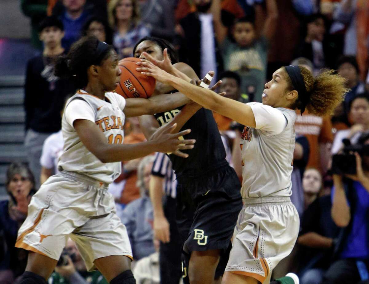Baylor's Khadijiah Cave, center, fights for the loose ball with Texas' Lashann Higgs, left, and Celina Rodrigo, right, during the second half of an NCAA college basketball game, Sunday, Jan. 17, 2016, in Austin, Texas. Baylor won 80-67. (AP Photo/Michael Thomas)