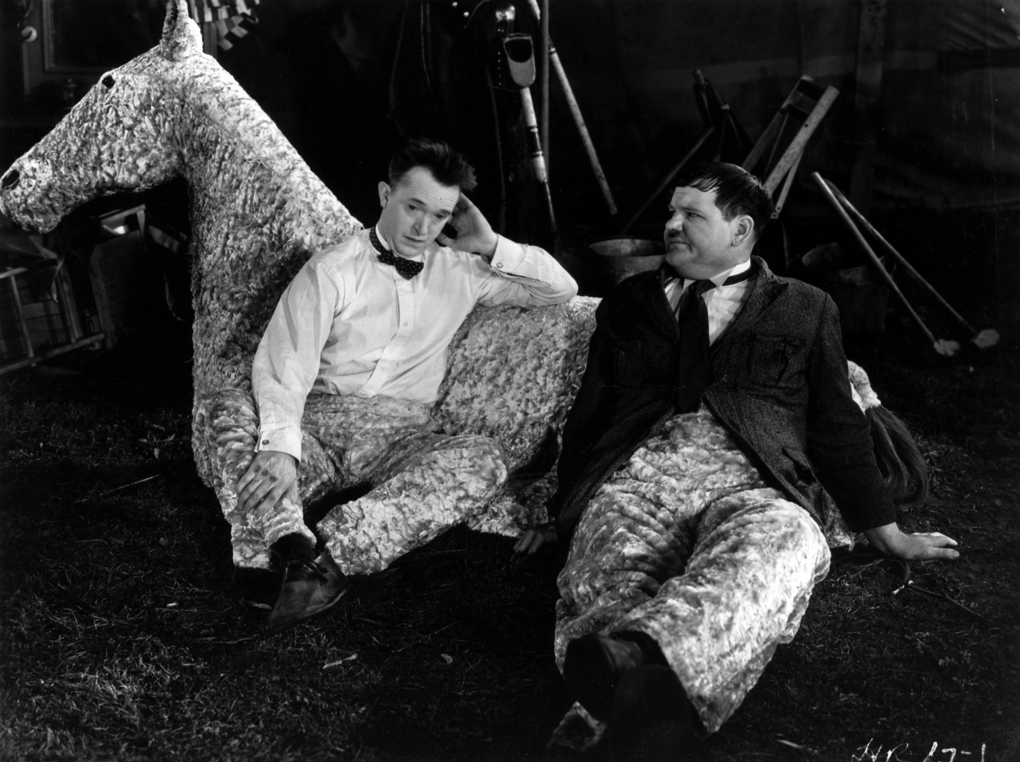 Comic duo Stan Laurel and Oliver Hardy take a break from playing the two sections of a pantomime horse, in the 1933 film film 'Monkey Doodle'.
