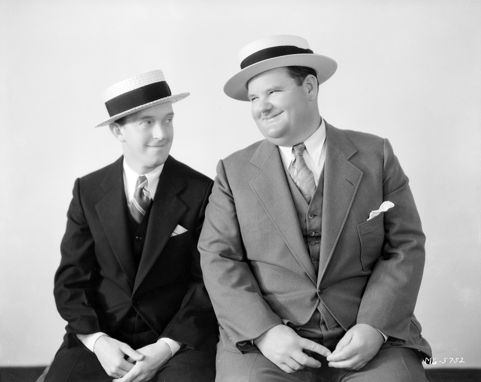 Stan Laurel and Oliver Hardy, wearing straw boaters instead of their trademark bowler hats, circa 1930.