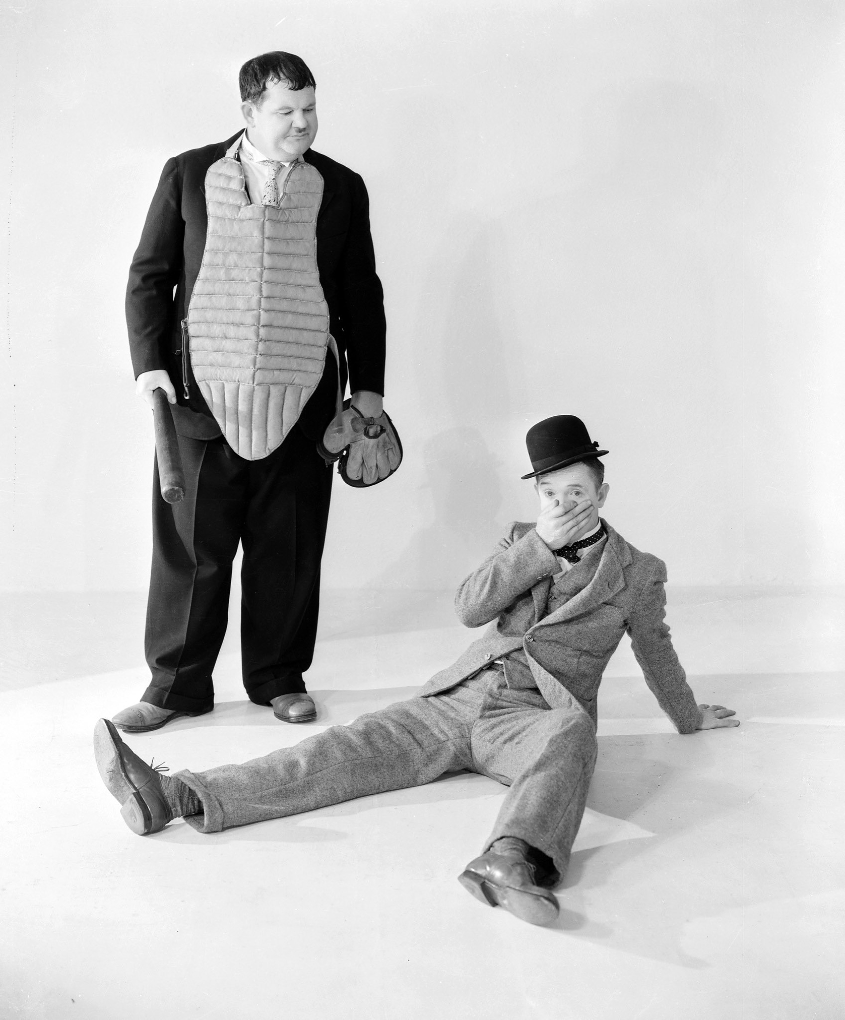 Stan Laurel holds his nose in pain after a sporting altercation with Oliver Hardy.