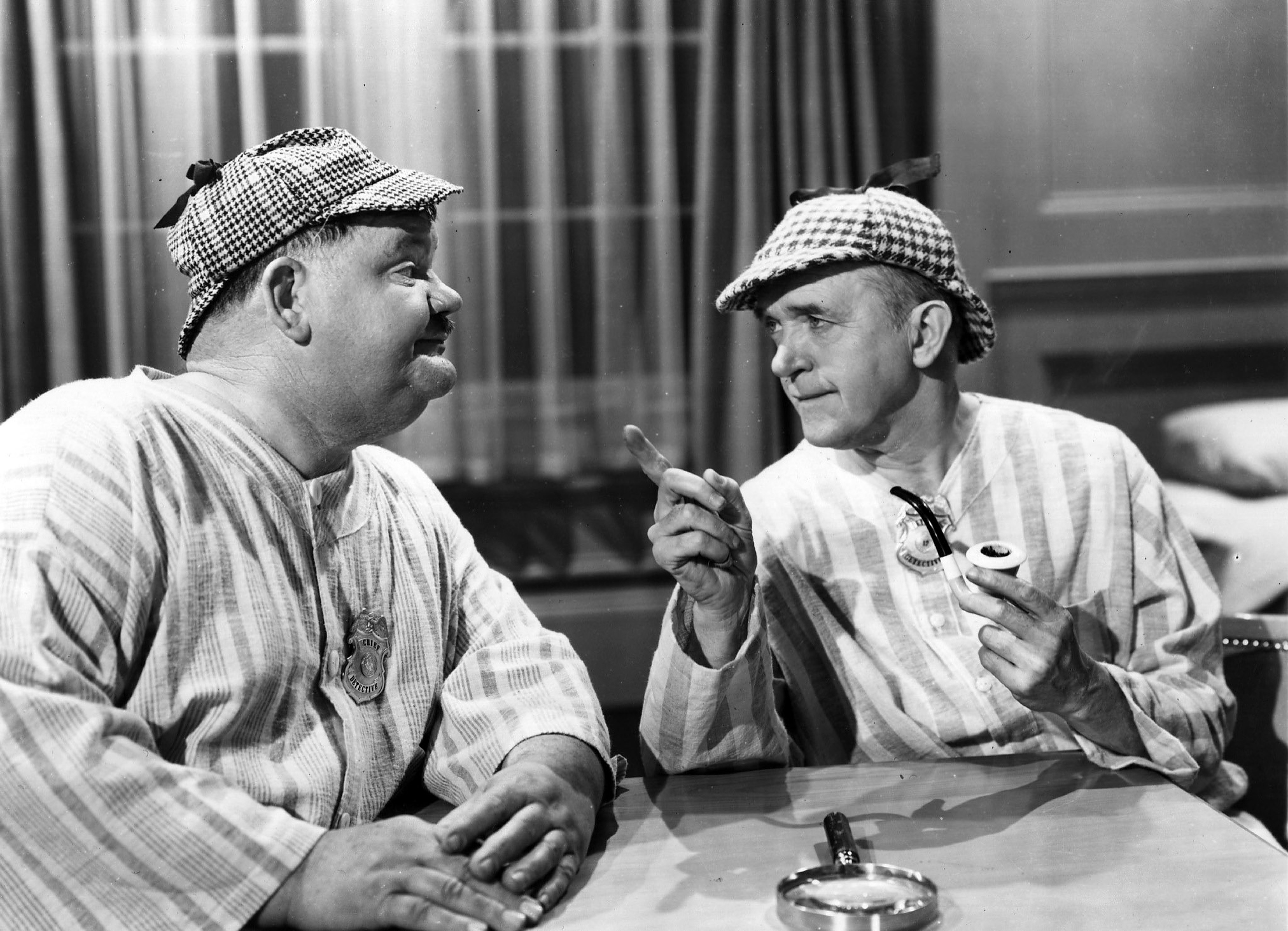 Stan Laurel and Oliver Hardy, wearing deerstalkers and nightgowns, play two incompetent detectives in the film 'The Big Noise', directed by Mal St Clair for 20th Century Fox, 1944.