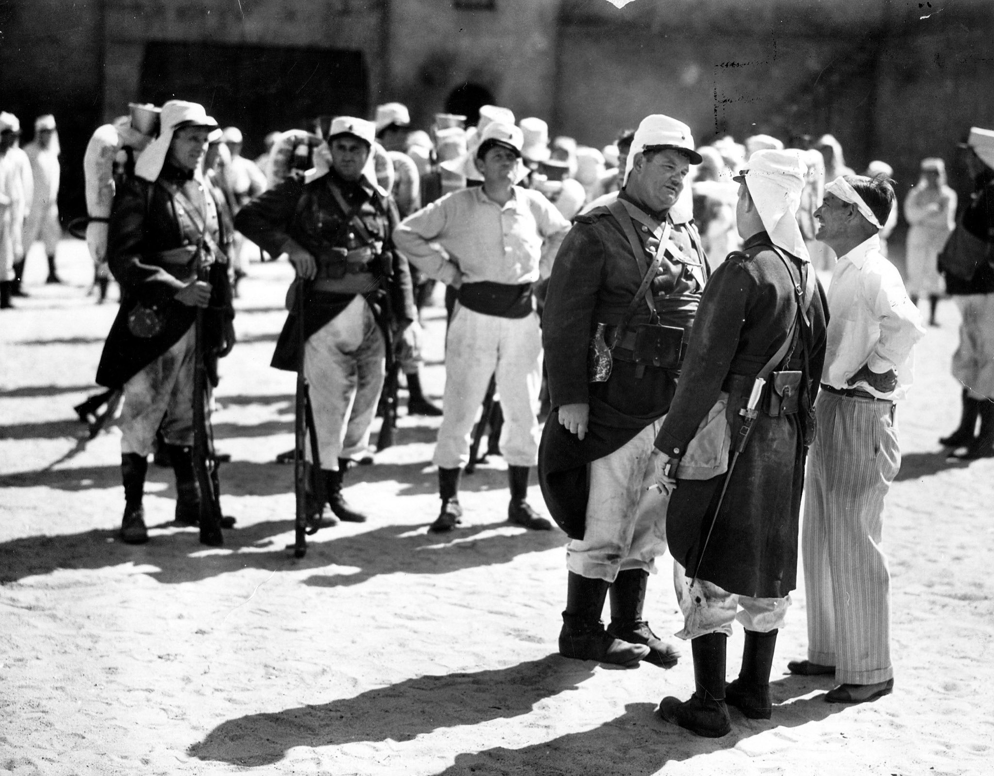 Laurel and Hardy star in 'Beau Hunks' the latest Hal Roach comedy about the Foreign Legion. The director James Horne is discussing with them how he wants the scene played, 1931.