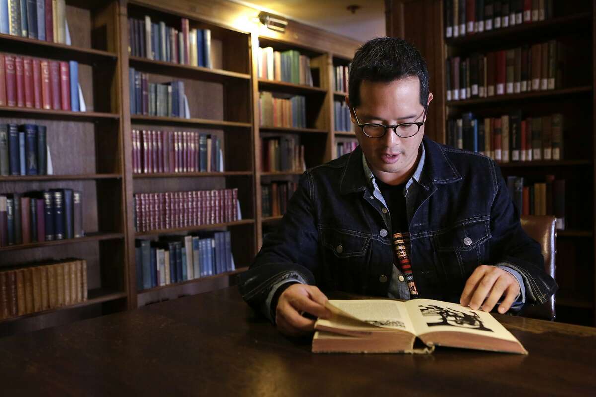 Jeff Chang leafs through a book in the Morrison Library on the U.C. Berkeley campus on Friday, October 17, 2014. The library was one of Chang's favorite hideaways while he was an undergraduate at the school. He was involved in activism and student government, and says his time at U.C. Berkeley helped spark his interest in politics and culture.