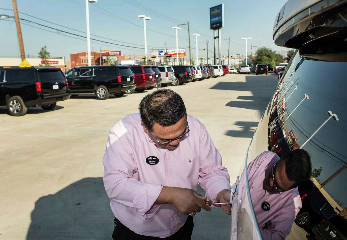 Salesman Freddy Barras puts a temporary tag on a new Chevrolet Tahoe for a customer at Knapp Chevrolet on Monday, Jan. 18, 2016, in Houston. Auto sales at the dealership was up 5.53 percent in 2015. ( Brett Coomer / Houston Chronicle )