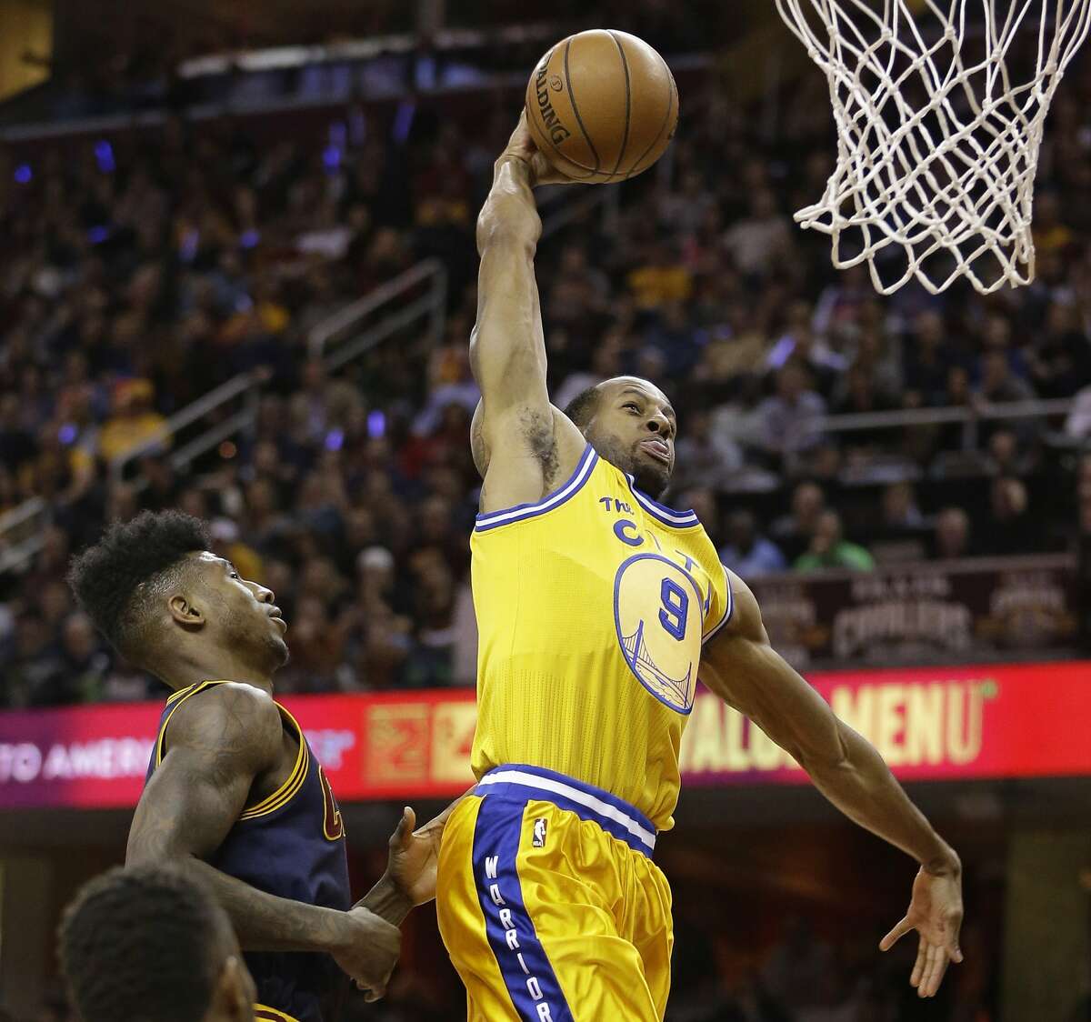 Golden State Warriors' Andre Iguodala (9) dunks the ball in front of Cleveland Cavaliers' Iman Shumpert (4) in the first half of an NBA basketball game Monday, Jan. 18, 2016, in Cleveland. (AP Photo/Tony Dejak)