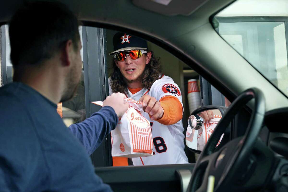 Colby Rasmus works the drive-thru window as he and Astros teammate Brad Peacock stop at the Whataburger in the Rim Shopping Center during an Astros Winter Caravan stop on Jan. 19, 2016.