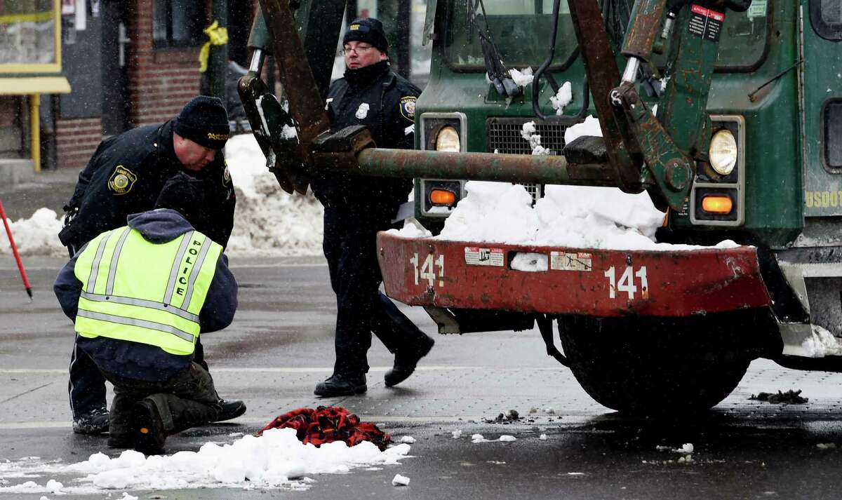 Albany Police forensics investigators gather at the front of a garbage truck involved in a serious personal injury accident at the intersection of Quail Street and Central Avenue Thursday morning, Feb. 12, 2015, in Albany, N.Y. (Skip Dickstein/Times Union archive)