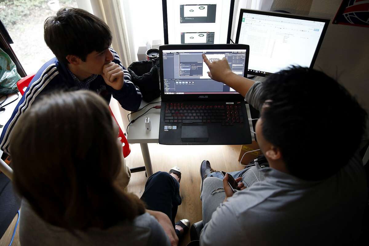 Jomar Sevilla (right) explains a program to interns Aaron Lewin (left) and Caitlin Clancy at STRIVR headquarters in Menlo Park, California, on Wednesday, Jan. 20, 2016.