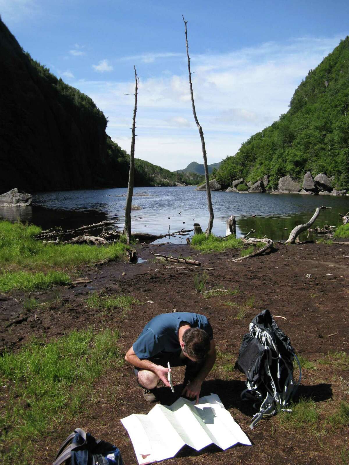 A hiking companion reviews a trail map during a hike in the High Peaks. (Herb Terns / Times Union)