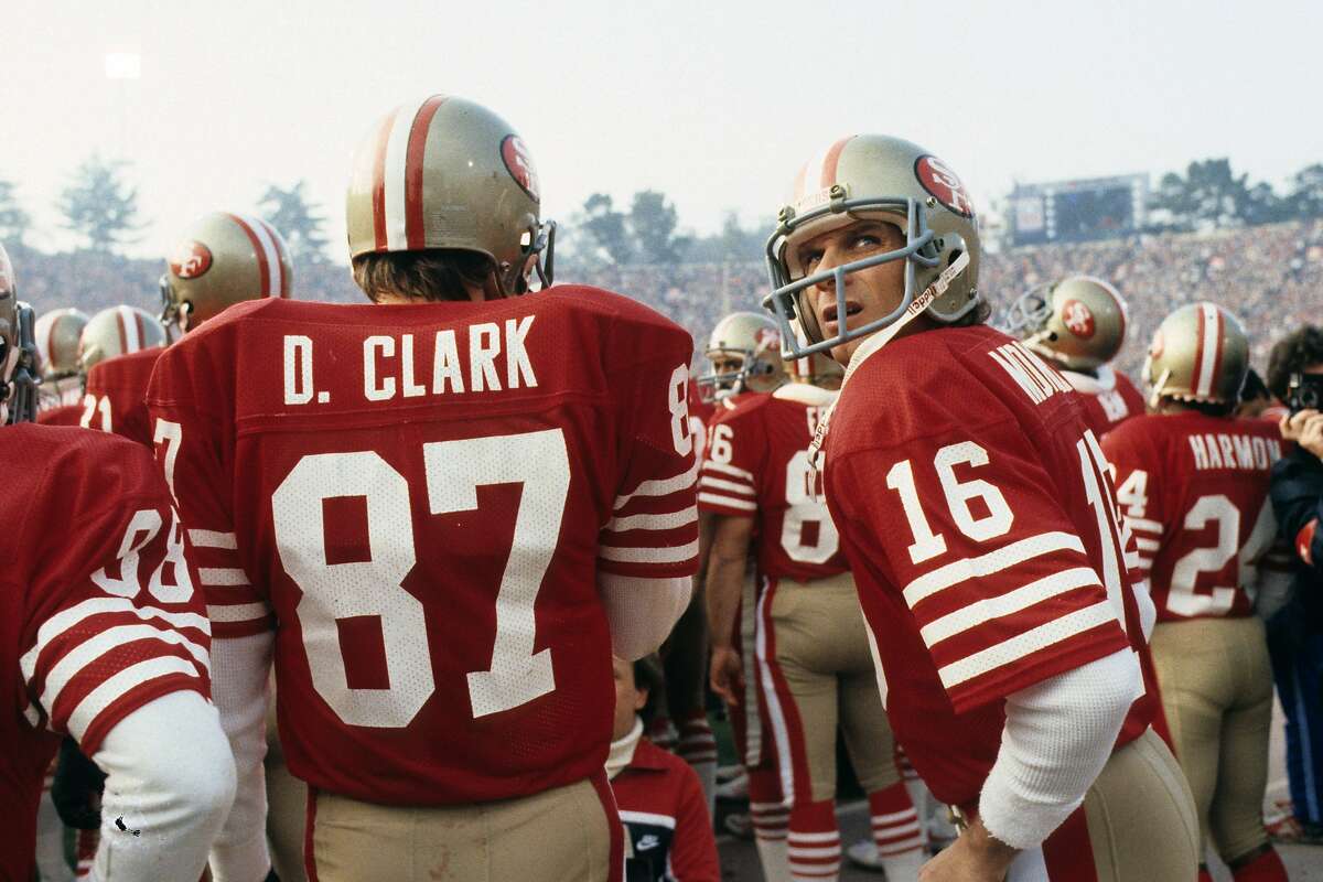 STANFORD, CA - JANUARY 20: Quarterback Joe Montana #16 of the San Francisco 49ers stands next to receiver Dwight Clark #87 prior to player introductions before the start of Super Bowl XIX against the Miami Dolphins at Stanford Stadium on January 20, 1985 in Stanford, California. The 49ers defeated the Dolphins 38-16. (Photo by George Gojkovich/Getty Images)