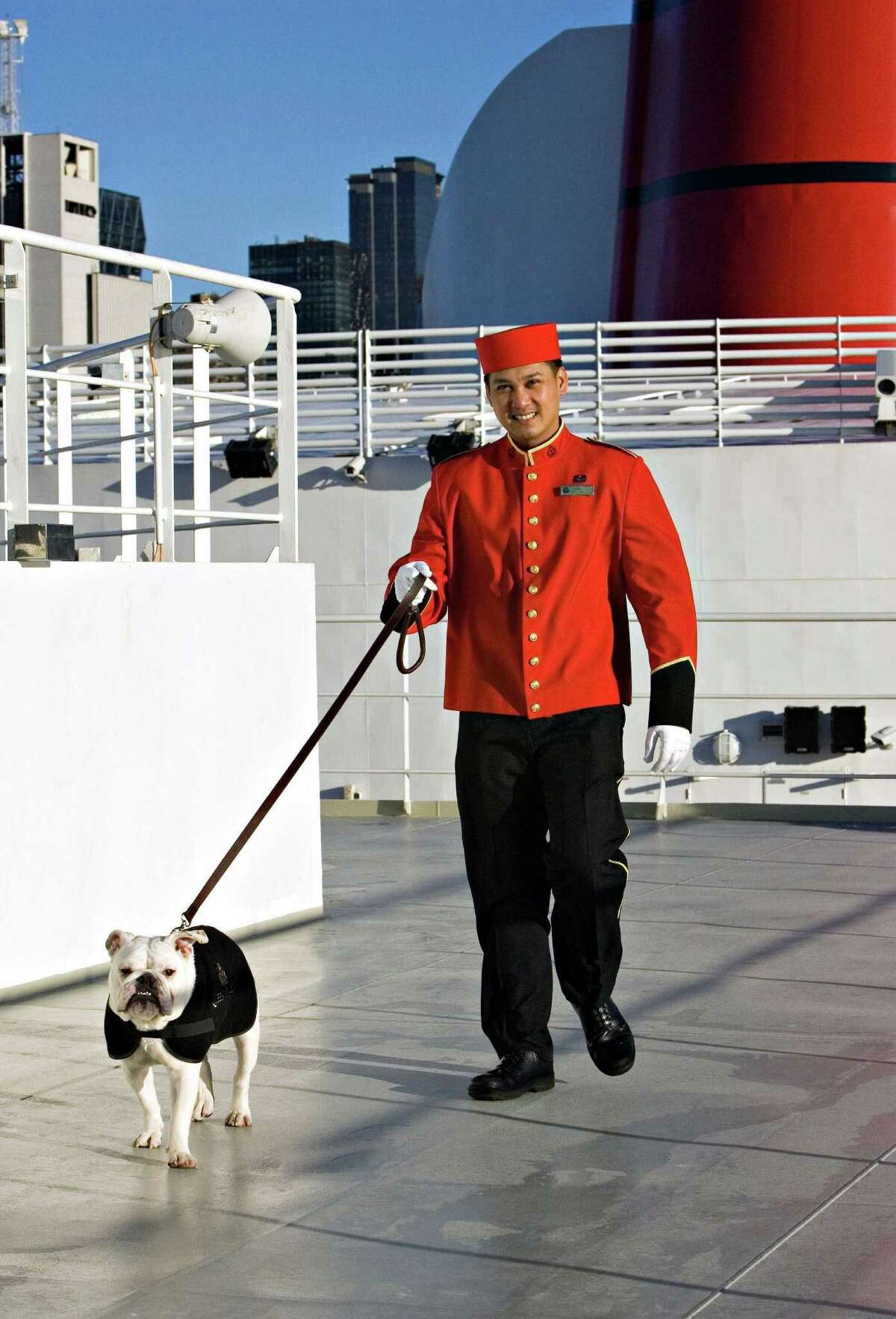 This undated photo from Cunard shows the cruise line's kennel master walking a dog on the top deck of the Queen Mary 2. The ship is going into drydock later this year for a renovation that will add family staterooms and rooms for solo travelers, as well as adding kennel space for canine passengers. (Cunard via AP) ORG XMIT: MER2016011410463460