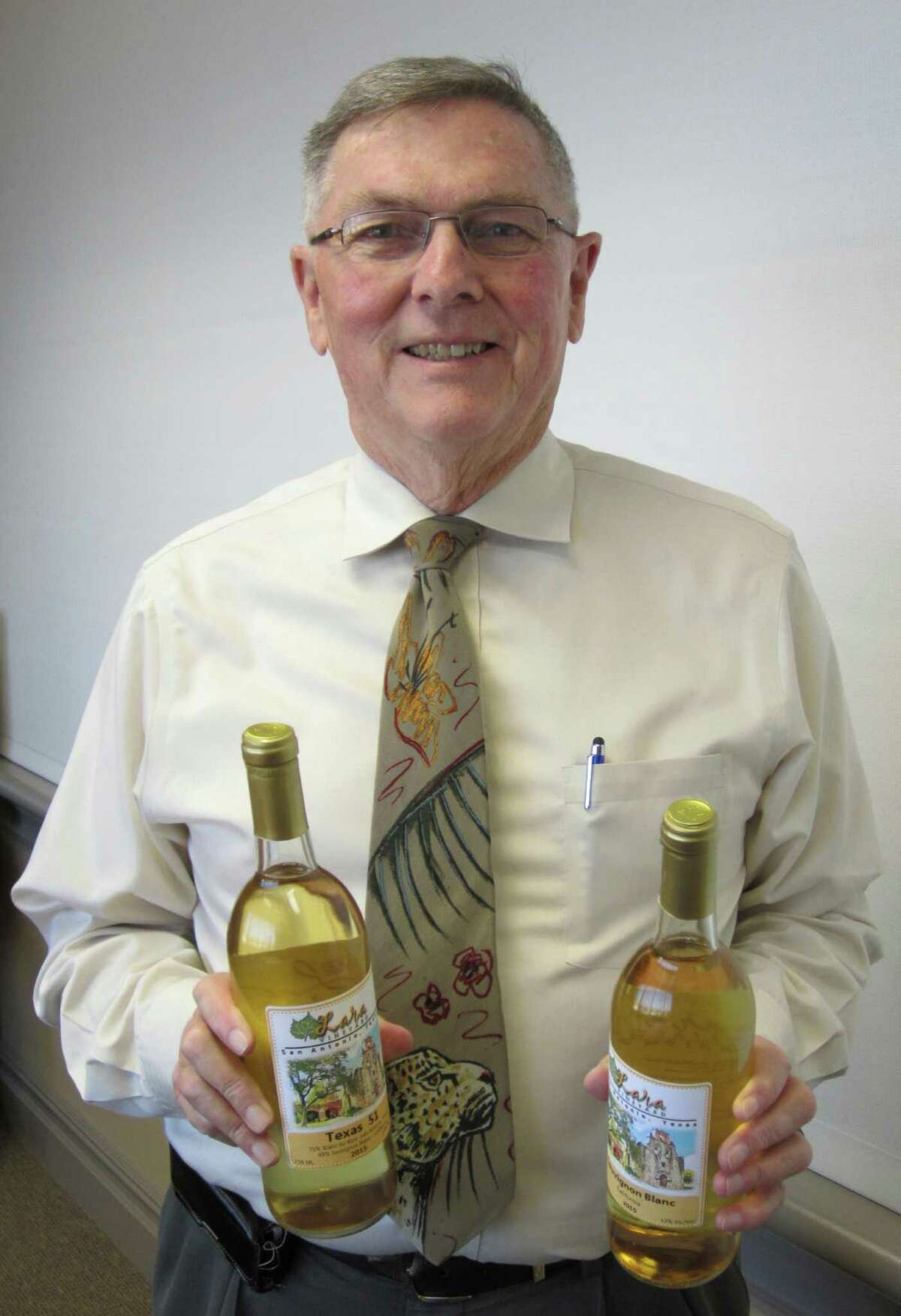 Intellectual property lawyer Ted Lee holds a couple bottles of wine produced by San Antonioâs Lara Vineyards.