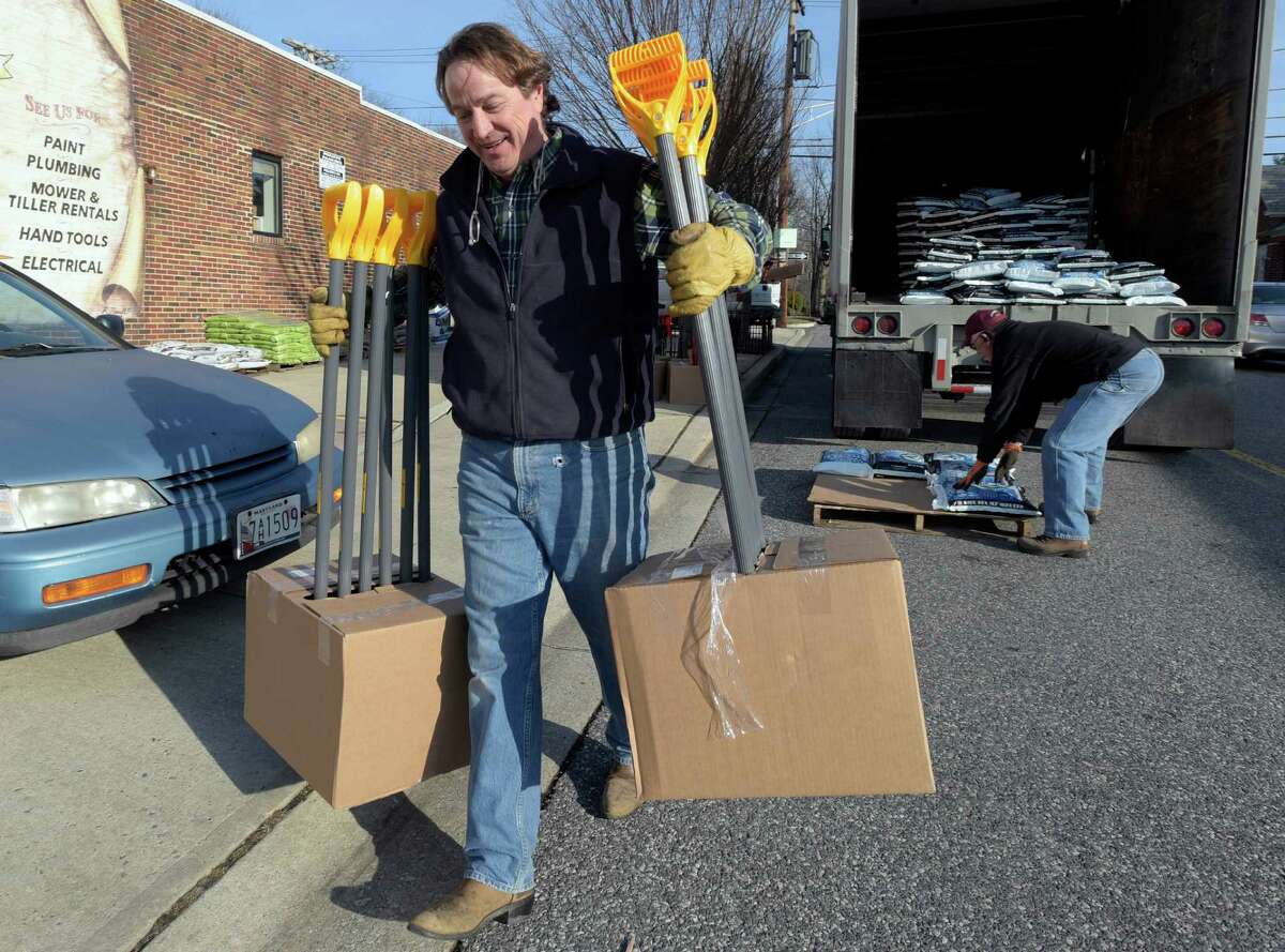 Vincent Ayd, left, owner of Ayd Hardware in Towson, Md., and truck driver Mike Jock, of Newark, Del., unload snow shovels and ice-melt in Towson, Thursday, Jan. 21, 2016. The northern mid-Atlantic region, including Baltimore, Washington and Philadelphia, is preparing for a weekend snowstorm that is now forecast to reach blizzard conditions. (AP Photo/Steve Ruark)