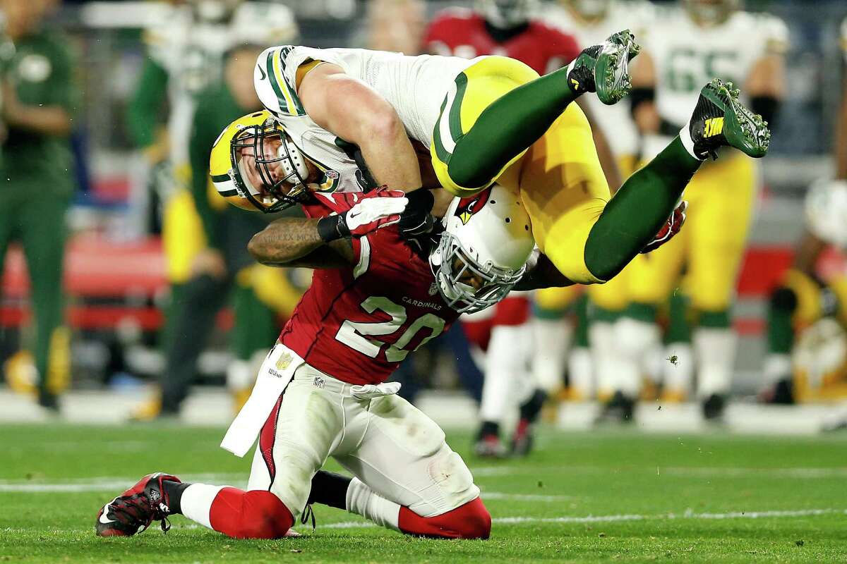 Fullback John Kuhn of the Green Bay Packers is hit by strong safety Deone Bucannon of the Arizona Cardinals during the second half of the NFC divisional playoff game at University of Phoenix Stadium on Jan. 16, 2016 in Glendale, Ariz.
