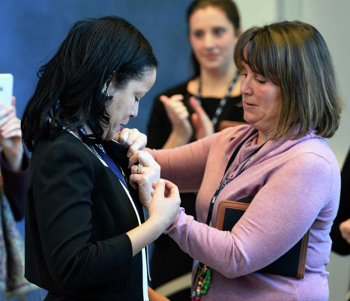 Zeonadis Tavarez receives her teaching certification pin from Susan Gray, co-director of NBCNY, Thursday morning, Jan. 21, 2016, during a press conference at the NYSUT offices in Latham, N.Y. (Skip Dickstein/Times Union)