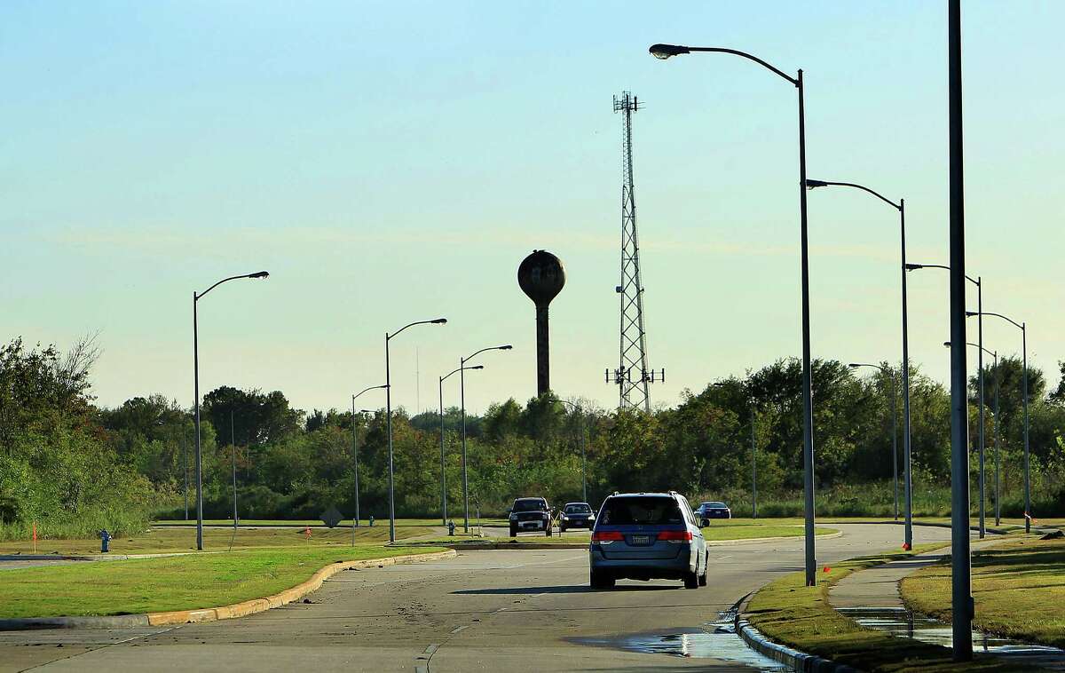 Cars drive along Willowbend Boulevard, which cuts through the center of 300 acres where the University of Texas plans to build a facility.