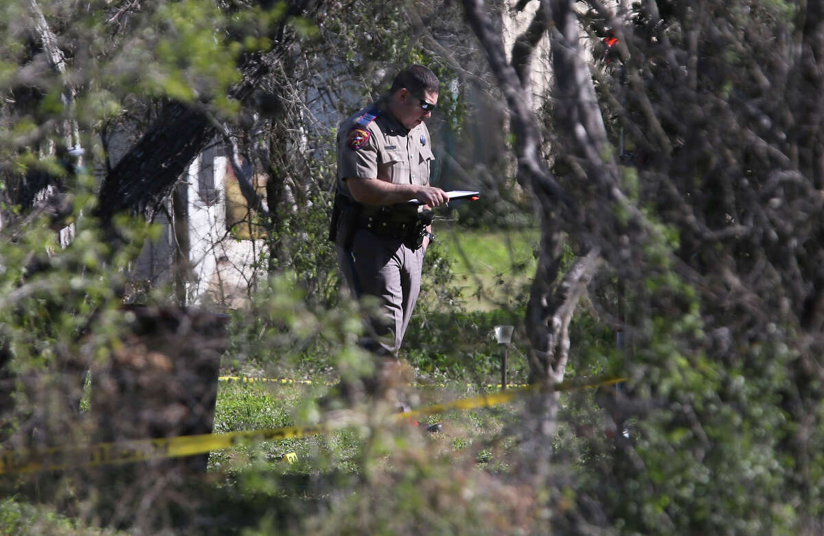 Law enforcement investigates Thursday January 21, 2016 in the back yard of a home in the Medina River West area just west of Castroville, Texas. Deputies received a call for an unresponsive woman in the neighborhood about 1:00 a.m. and there were reports of a pickup truck leaving the area. The truck was stopped on Highway 90 and after several hours the truck's driver surrendered and a second body was found in the truck.