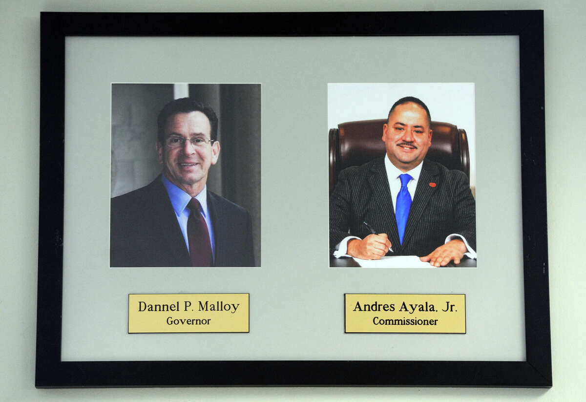 Portaits of Gov. Dannel P. Malloy and Motor Vehicles Commissioner Andres Ayala hang in the Bridgeport DMV offices.