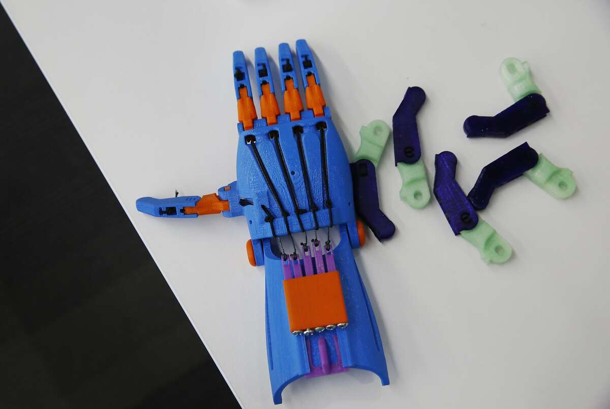 A finished prosthetic hand and fingers after they were made by a 3D printer sit on a nearby desk to be used as examples at the Bridge at Main Learning and Literacy Center Jan. 21, 2016 in the main San Francisco Public Library in San Francisco, Calif. The Center has had the 3D printer for about a year. They use it to teach digital literacy to people of all ages and recently started printing simple prosthetic hands they can donate to children as well as use them as examples to their students of what a 3D printer can do.