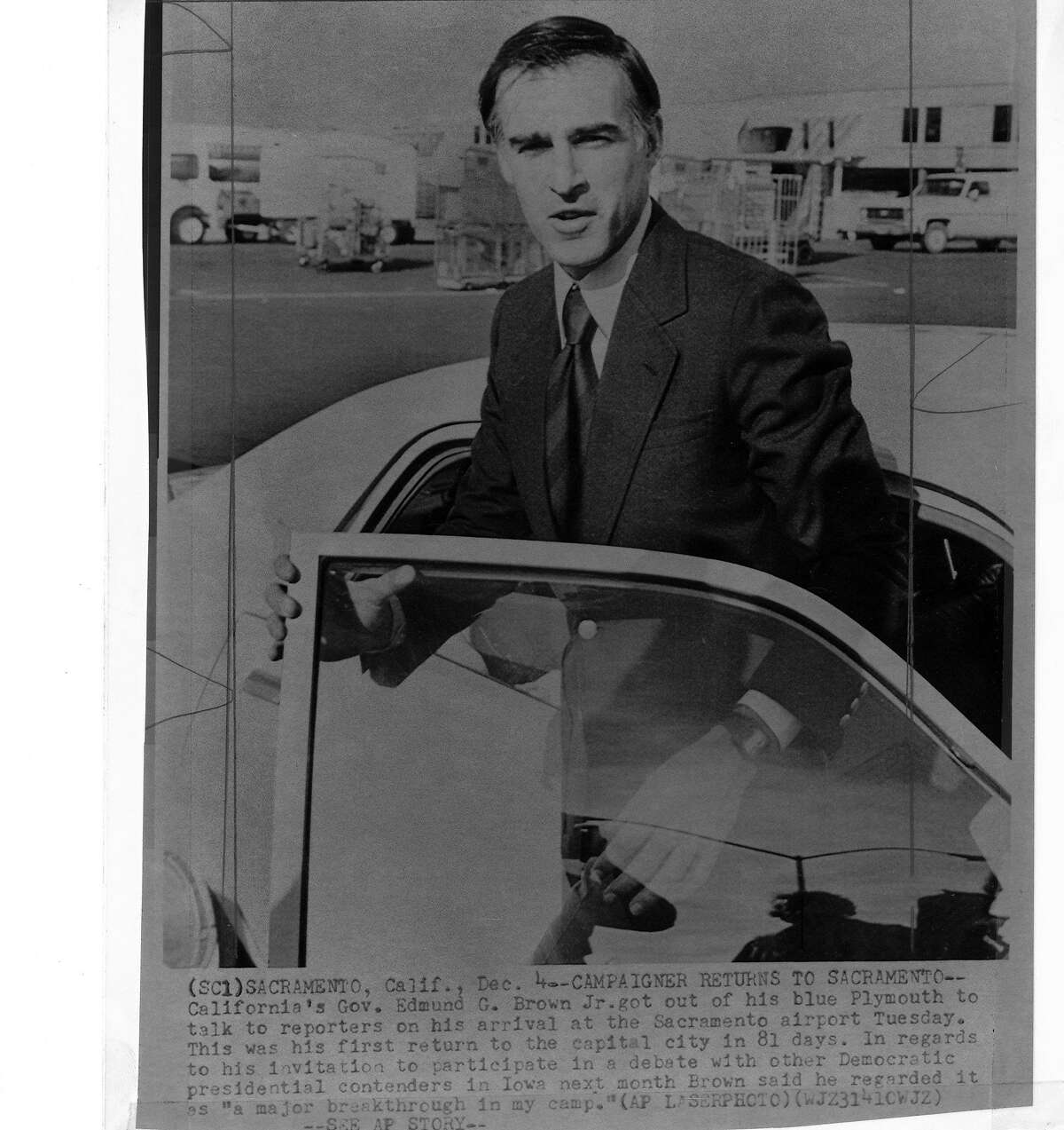 Governor Jerry Brown talks to reporters as he gets out of his blue Plymouth photo ran 12/5/1979, p.18