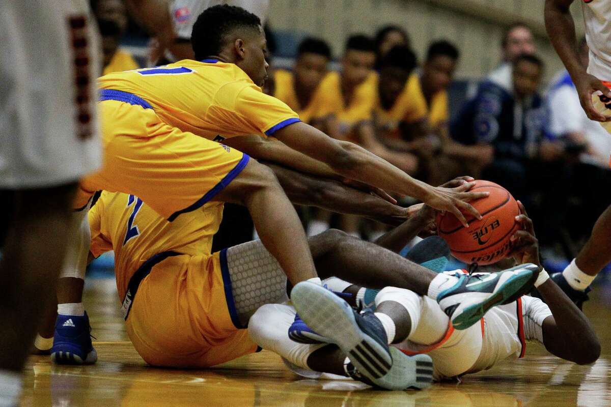 Elkins' Tyrik Armstrong, left, reaches for the ball in an attempt to steal it from Bush's Bradley Trevion as Bush beats Elkins 61-60 at Wheeler Fieldhouse Friday, Jan. 22, 2016, in Sugar Land.