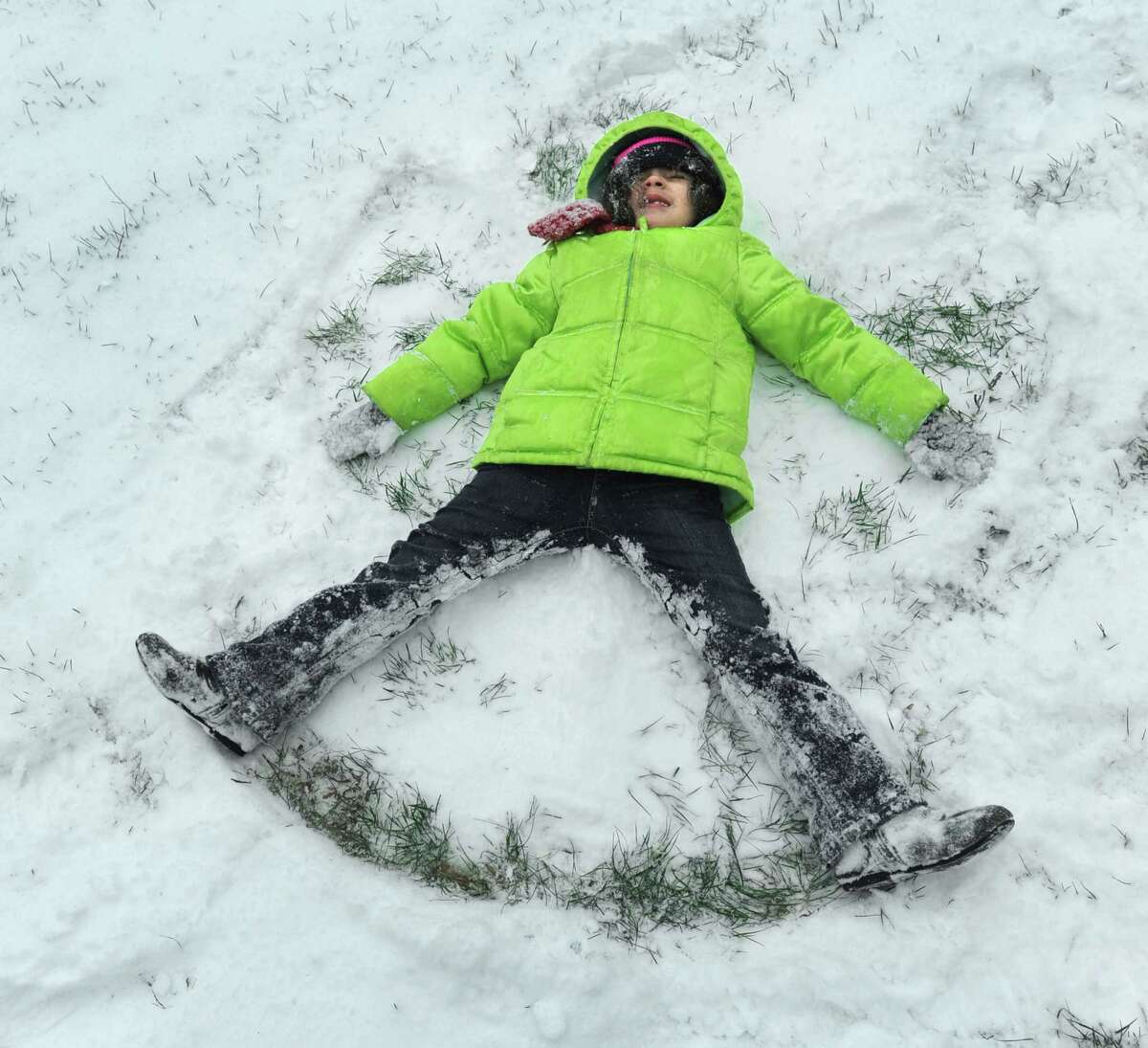 Christine Billerback, 4, makes a snow angel in the from yard of her Park Avenue apartment in Danbury, Saturday, morning, January 23, 2016. Snowfall in Danbury was moderate before Noon on Saturday, January 23, 2016.