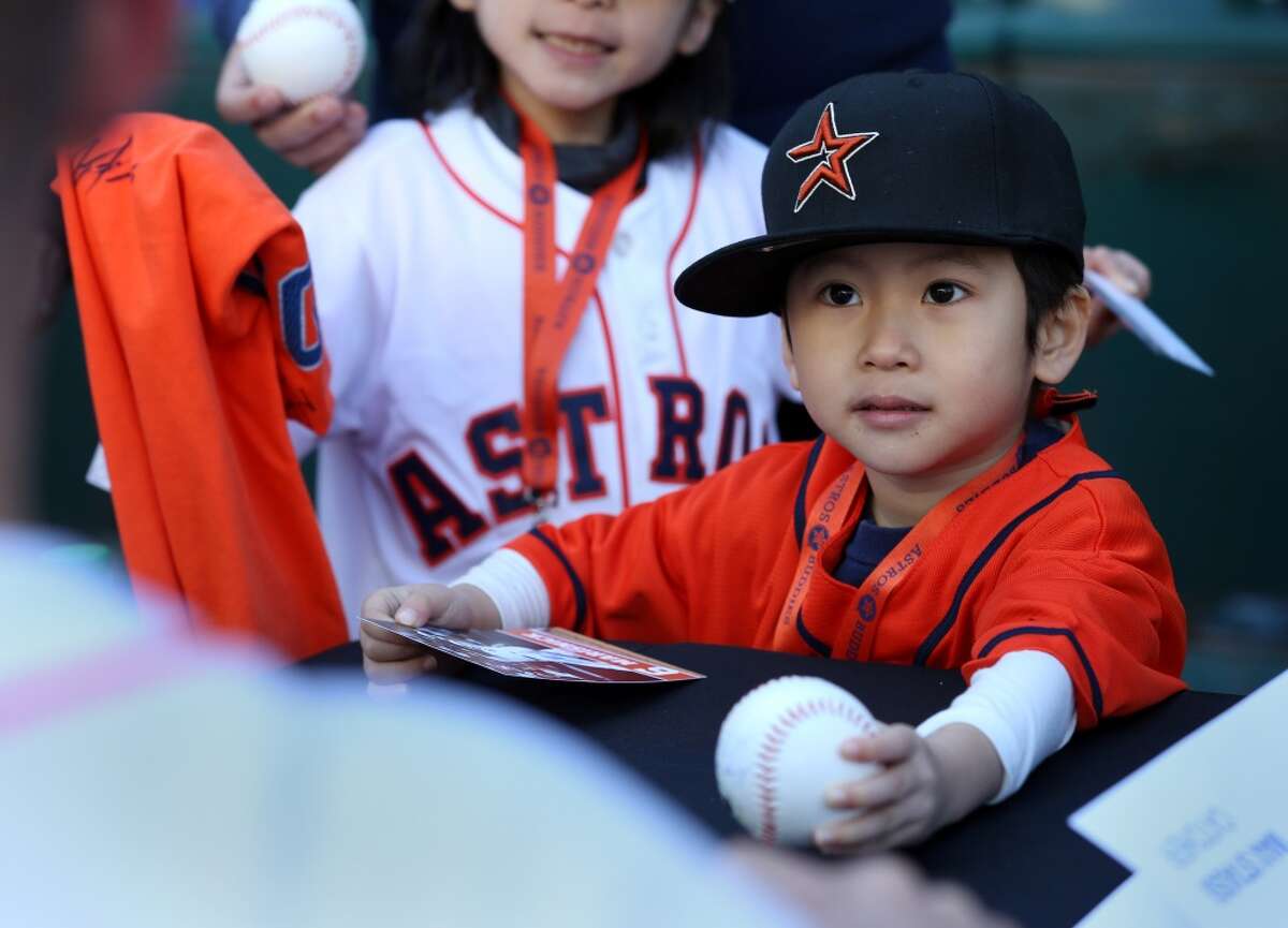 Daisuke Nakamura, 4, hands a baseball to Houston Astros catcher Max Stassi (12) for an autograph at Astros fan fest at Minute Maid Park Saturday, Jan. 23, 2016, in Houston. ( Jon Shapley / Houston Chronicle )