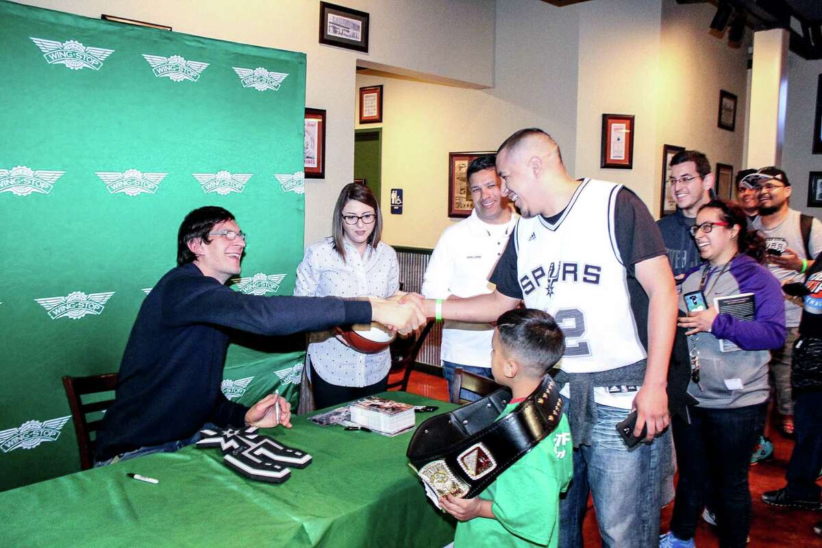 Spurs player Boban Marjanovic signs an autograph for a fan at recent appearance at a local Wingstop restaurant.