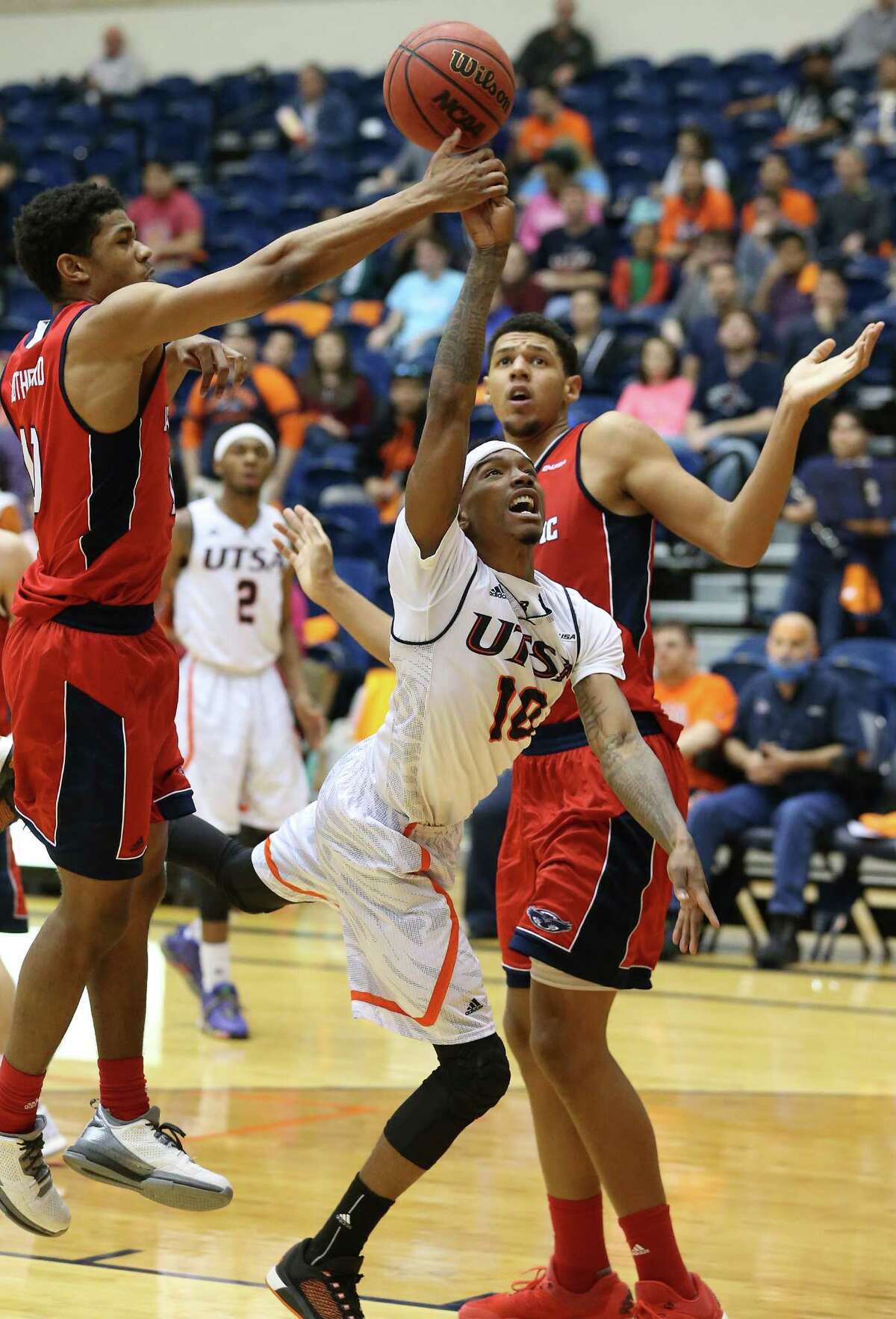 Christian Wilson gets fouled as he takes the ball in to challenge Nick Rutherford (left) and Ronald Delph as UTSA hosts Florida Atlantic in men's basketball at the UTSA Convocation Center on January 23, 2016.