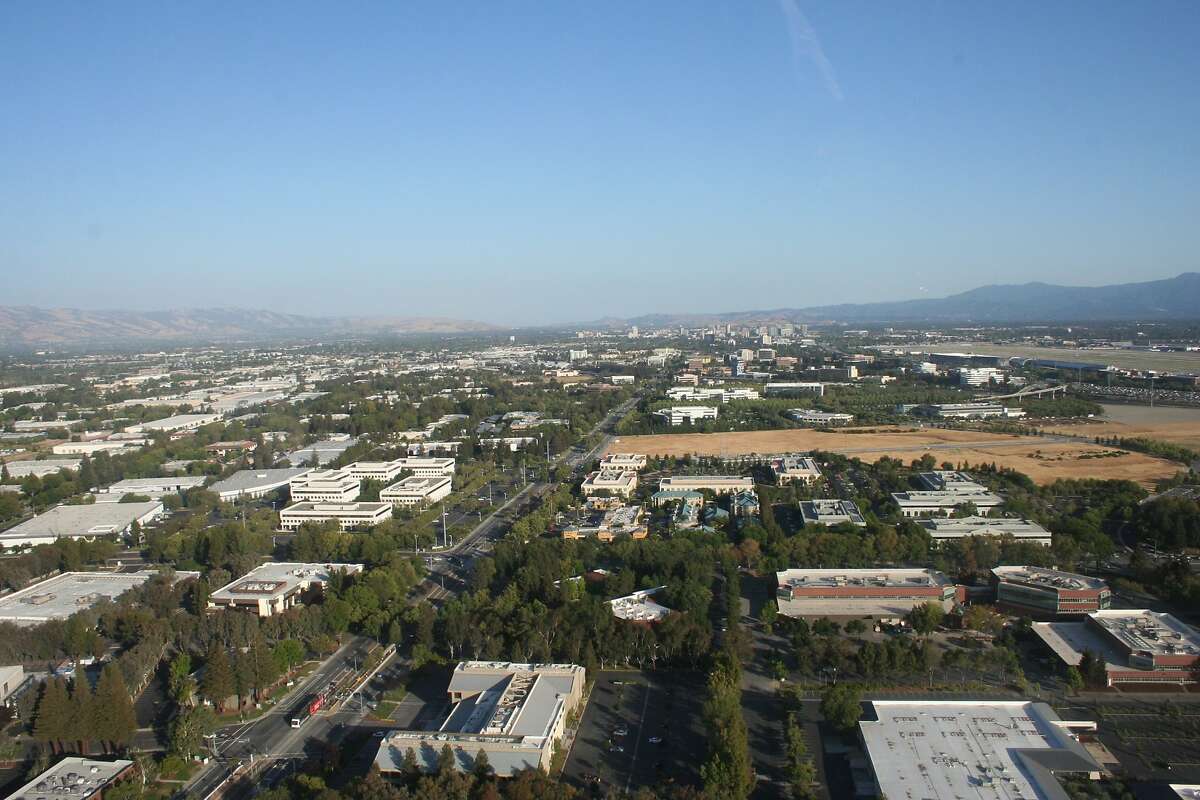 North First Street, center of photo, is a main artery from downtown San Jose to the northern city, and includes light rail access. San Jose Mineta International Airport is seen on the right. Part of the open field, center, is among Apple's purchased lands in North San Jose. The area has easy access to the airport, hotels, universities, and transit options.