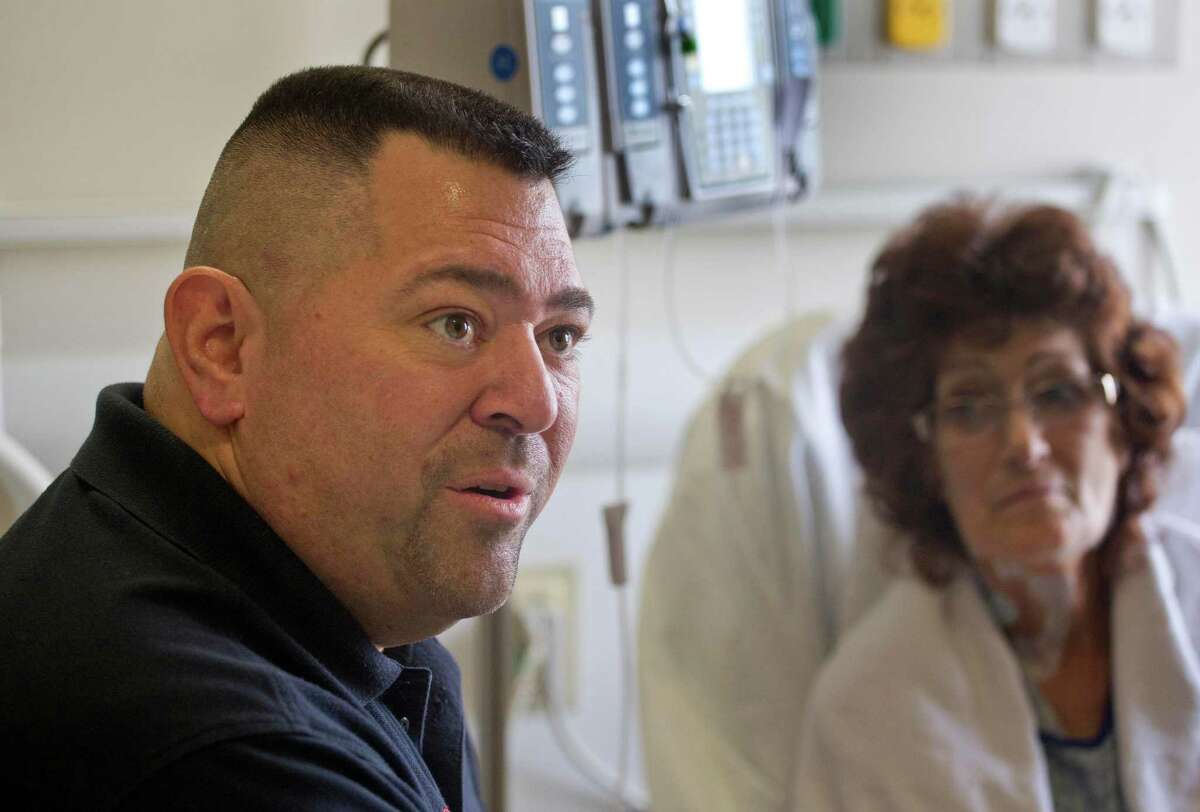 Paramedic Pete Amato, left, answers questions during an interview Tuesday while visiting with Stony Brook University Hospital patient Melanie Chirichella.